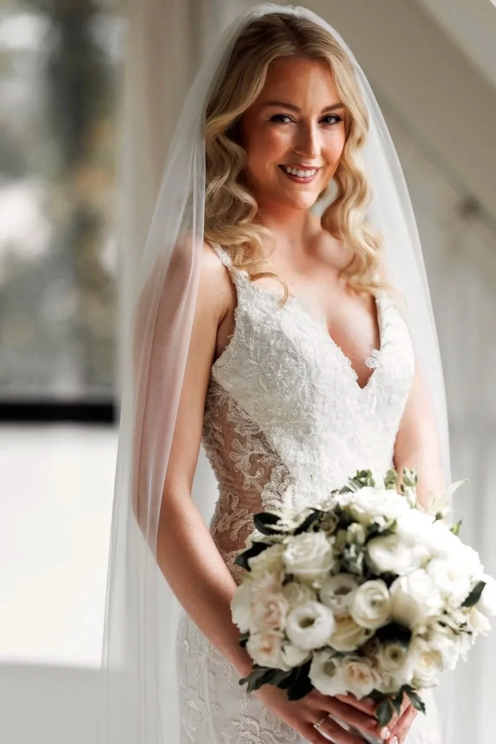 Bride with bouquet of white Ranunculus and Roses