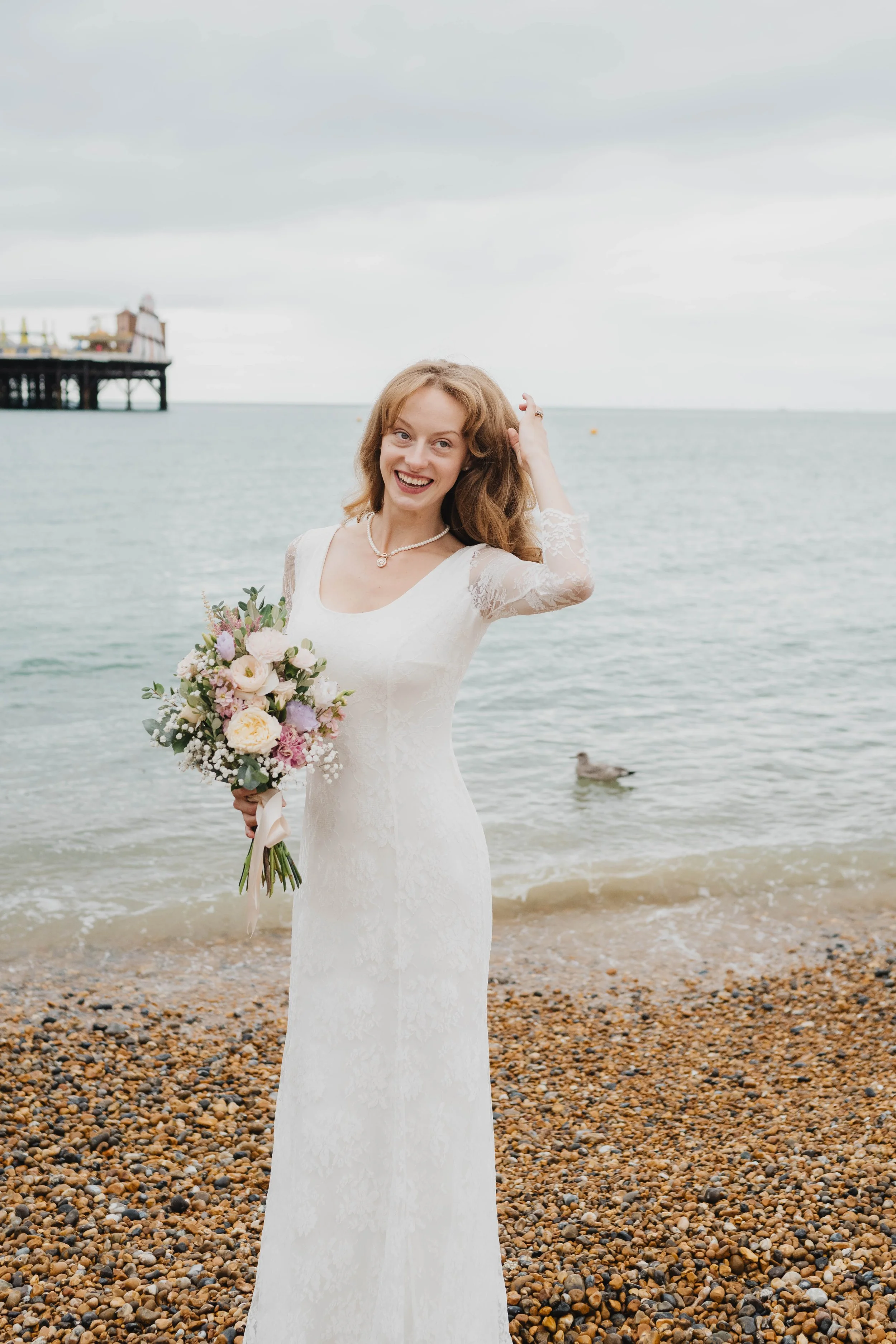 Bride on beach with pastel bouquet