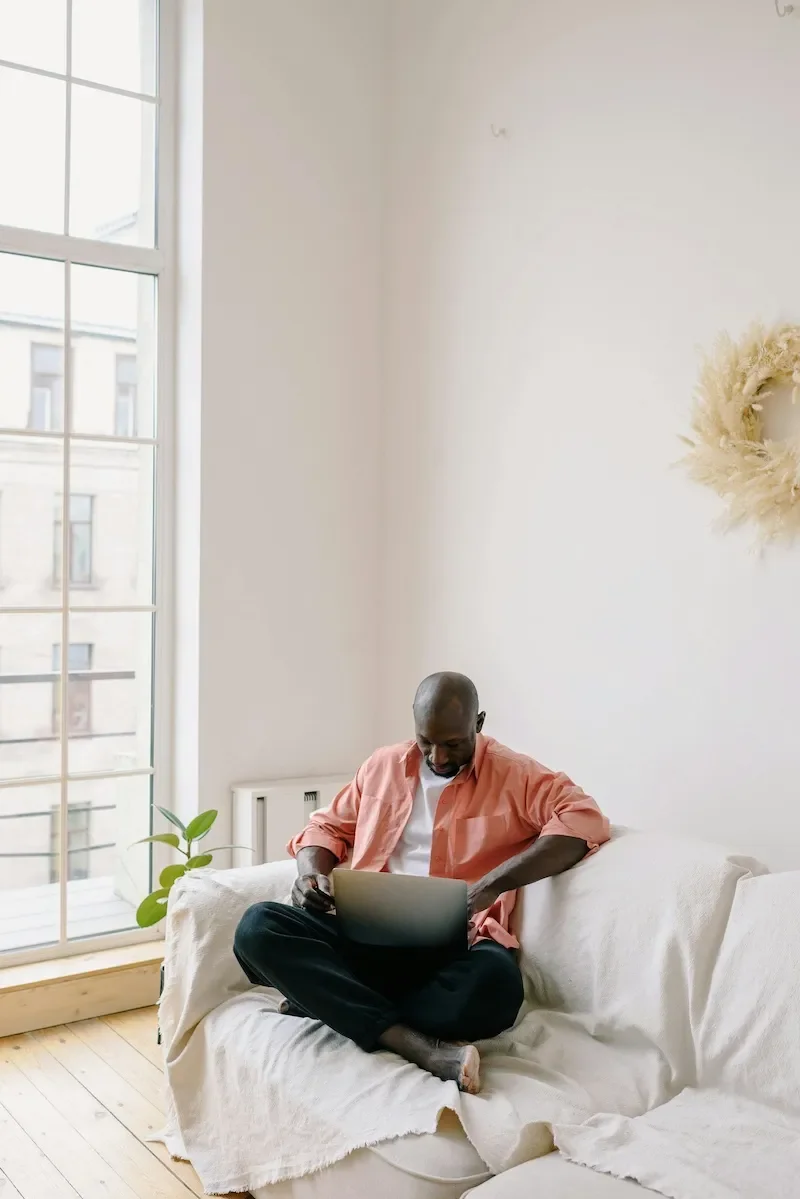 man on sofa using laptop