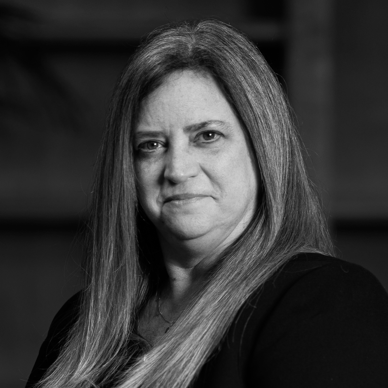 Black and white portrait of a woman with long hair, looking at the camera.
