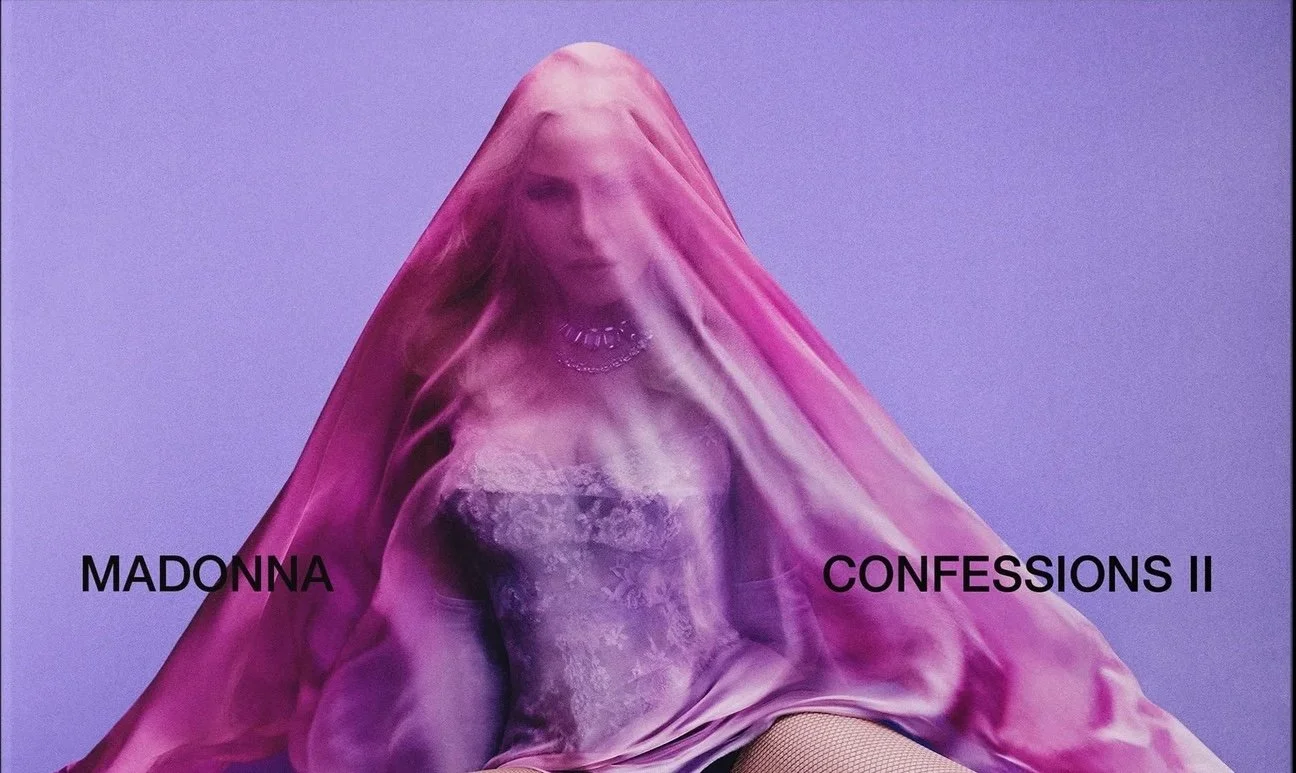 Album cover for Madonna's "Confessions II" featuring Madonna behind a pink sheer veil, with text on the left reading "Madonna" and on the right reading "Confessions II".