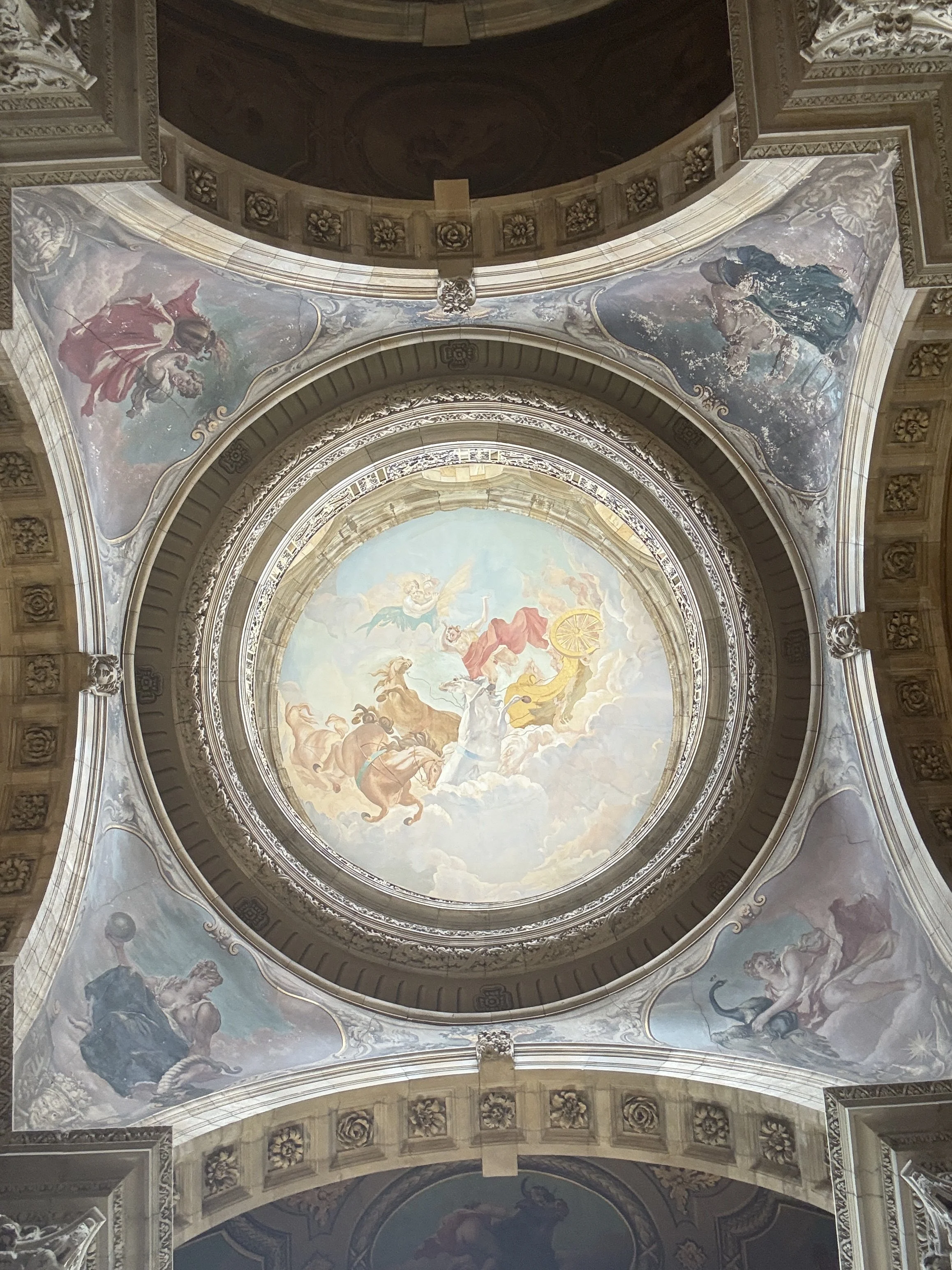 Painted fresco on a domed ceiling depicting mythological figures and clouds, surrounded by ornate architectural details.