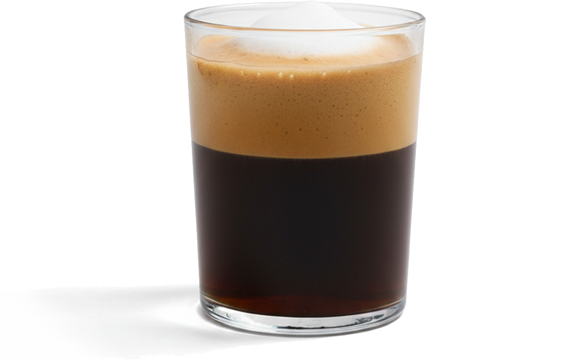 Macchiato in a clear glass with layered espresso and foam by X° Robusta.