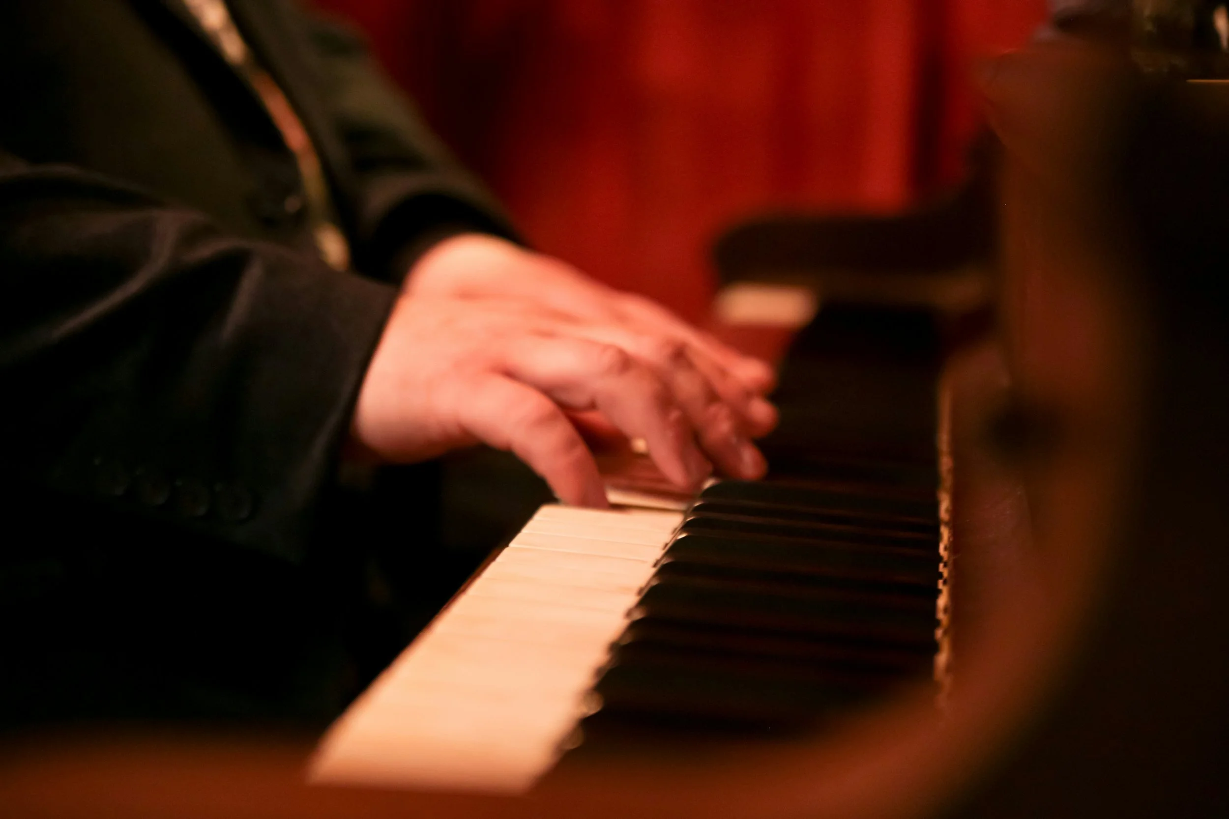 Close-up of hands playing a piano keyboard