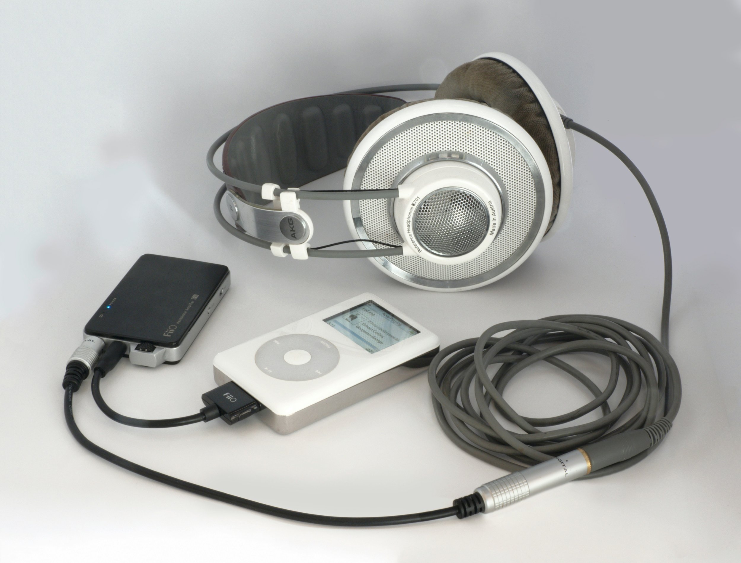 Headphones connected to a portable audio amplifier and an MP3 player.