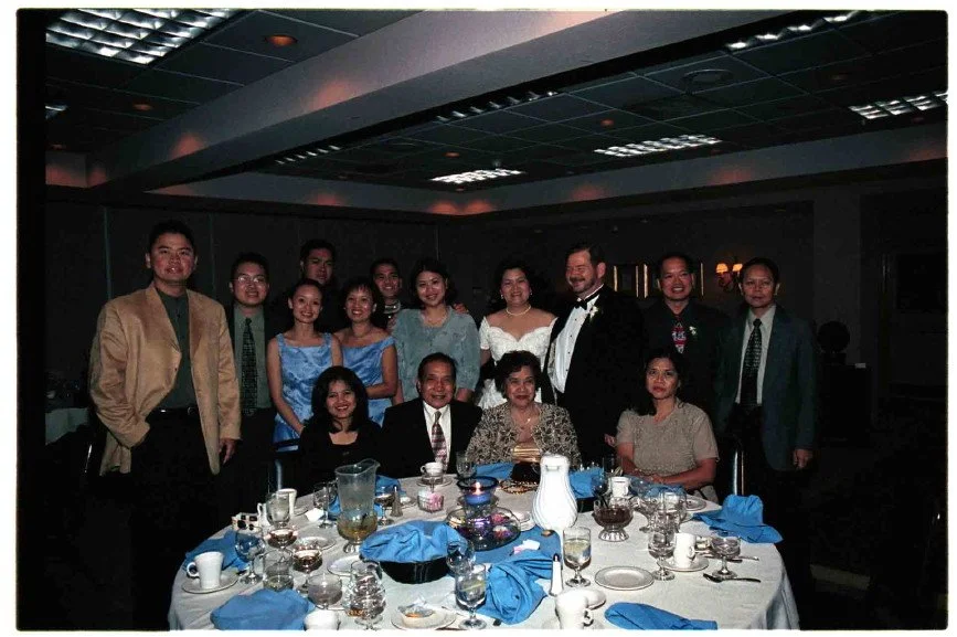 Group of people dressed formally around a dining table at an event.