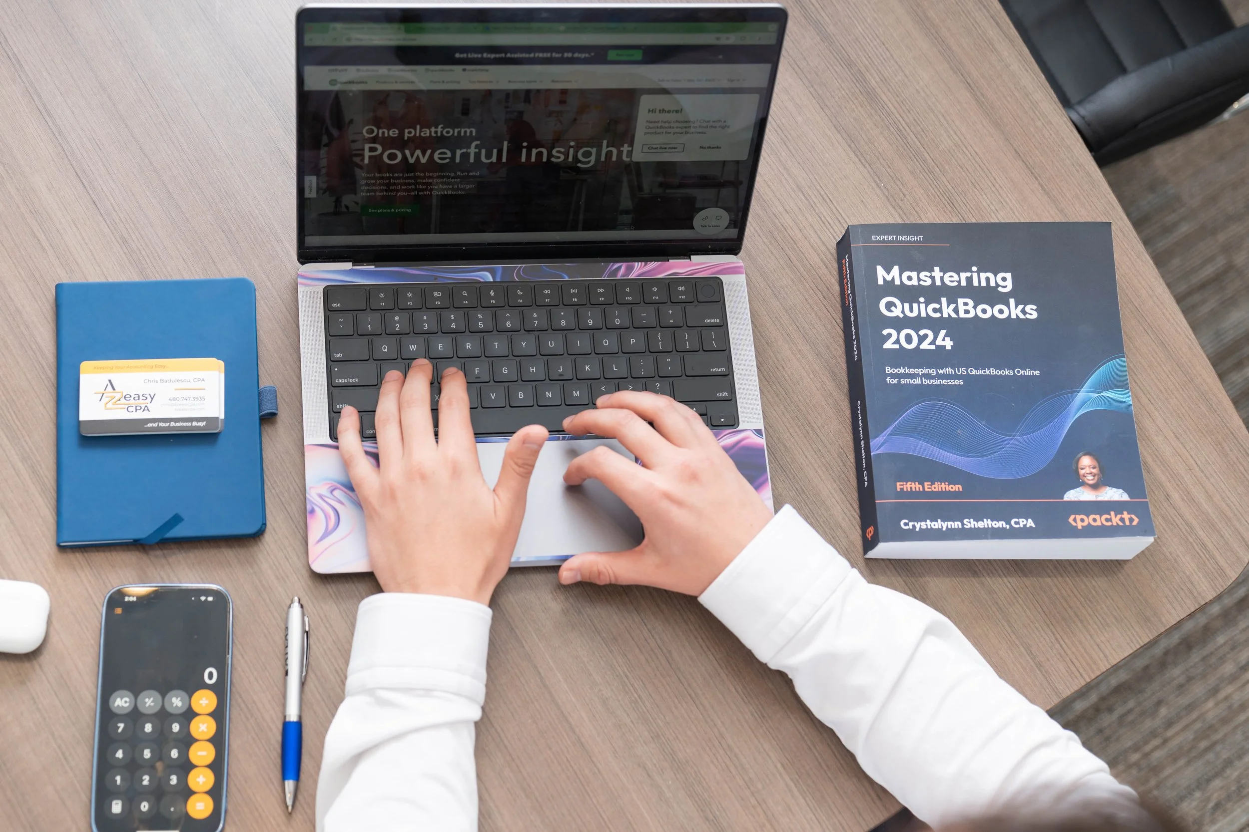 Custom image of Chris' hands on laptop including his business cards and quick books for his brand photoshoot