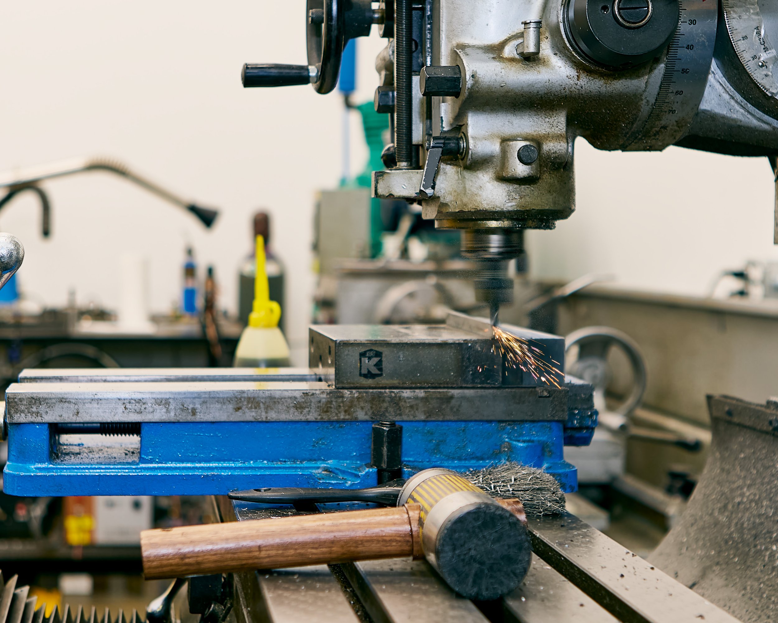 A metalworking machine in a workshop, with sparks flying from a tool working on a metal piece.