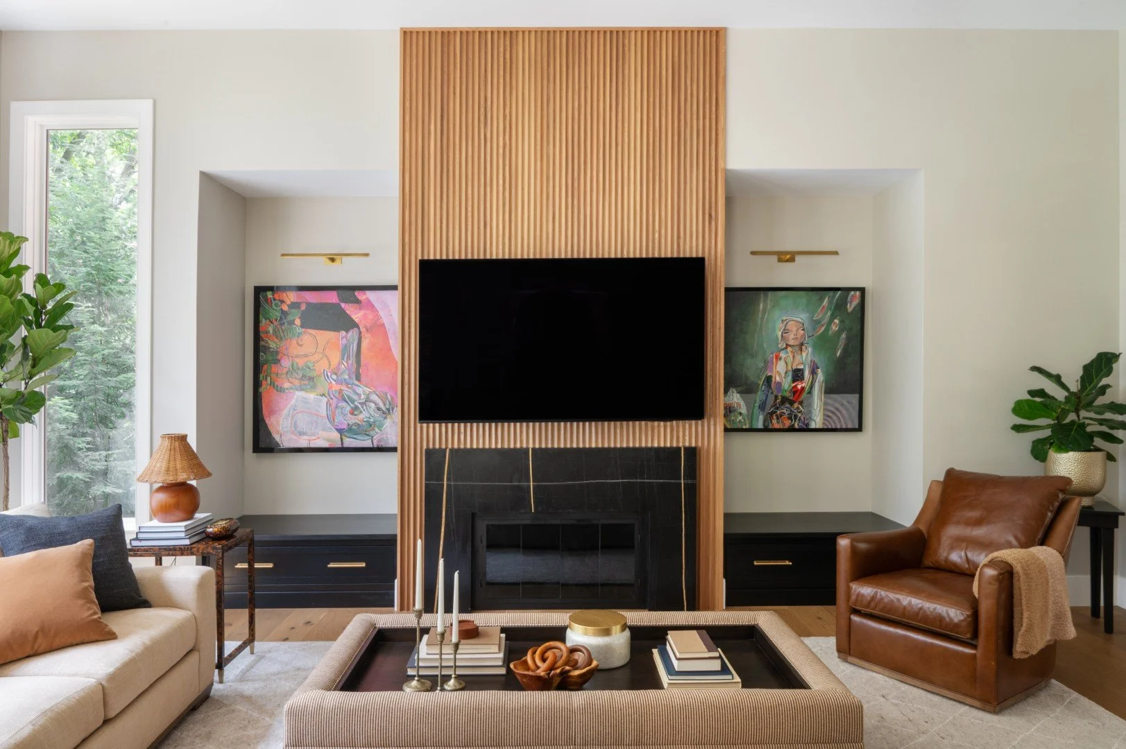 interior design for the living room of iron gate house in South Bend, Indiana featuring wooden backsplash, earth-tone leather furniture, and art on the wall
