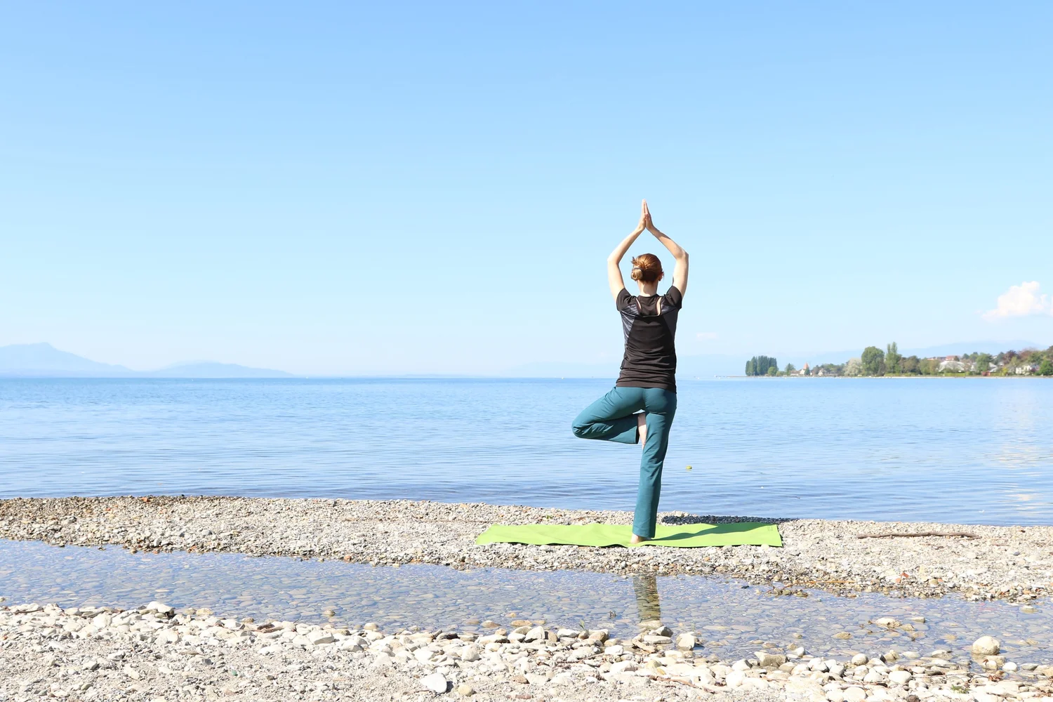 Maude pratique le yoga au bord du Léman, face aux montagnes