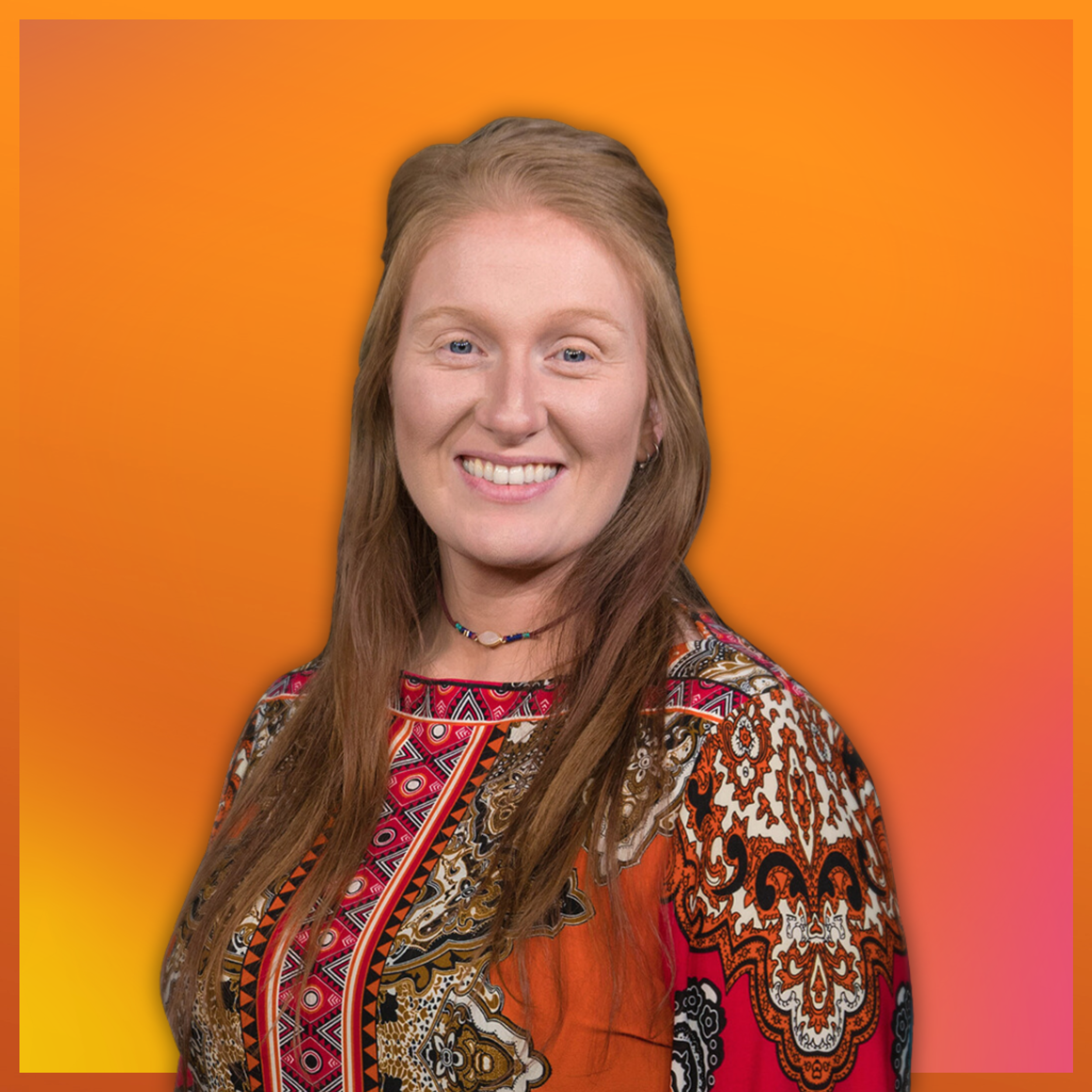 Donna Howell, who has long red hair smiling, wearing a colorful patterned top, against an orange and pink gradient background.