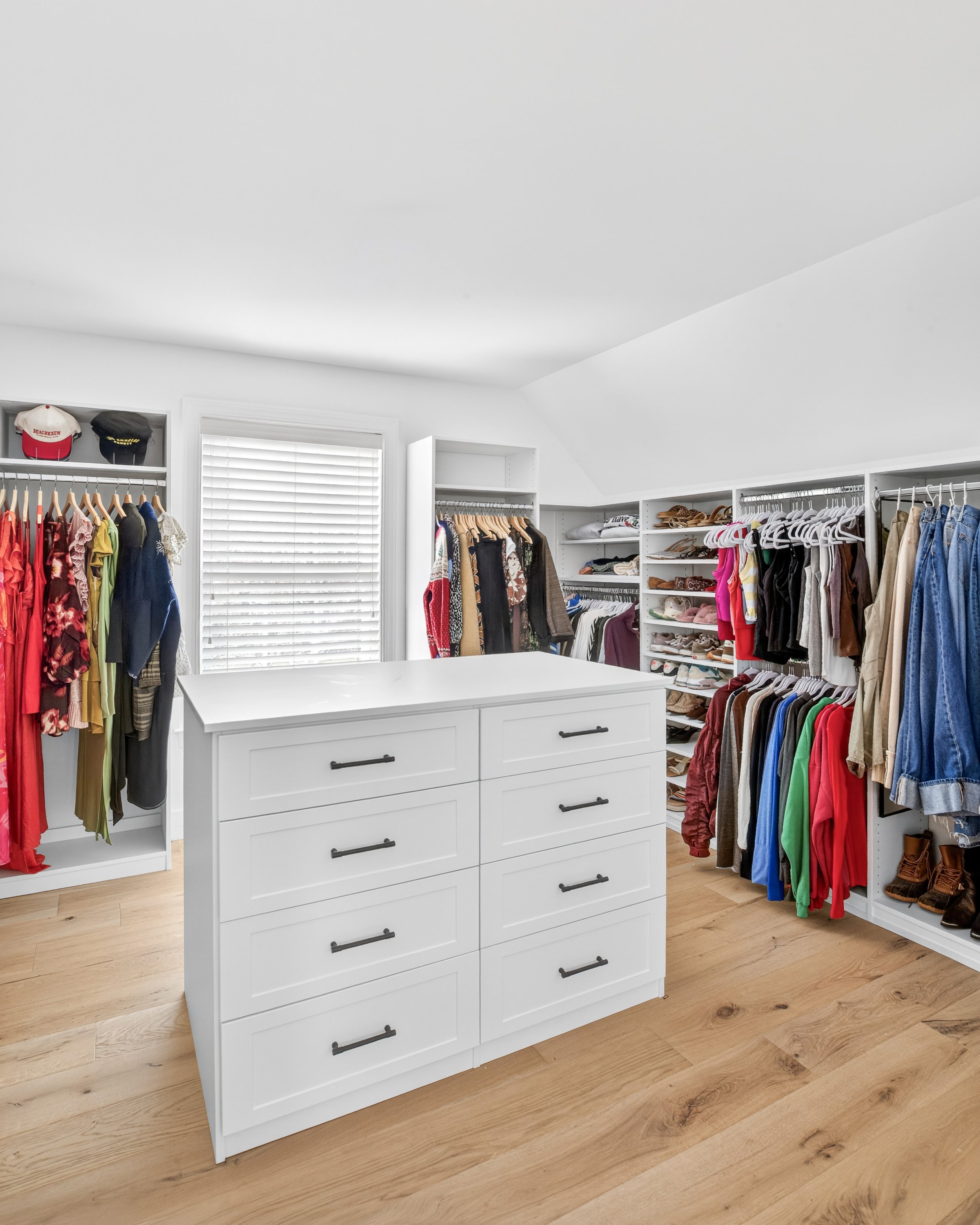 Luxury custom walk-in closet in Waxhaw, NC featuring a center island, soft-close drawers, adjustable shelving, and double hanging rods by Agape Closets.