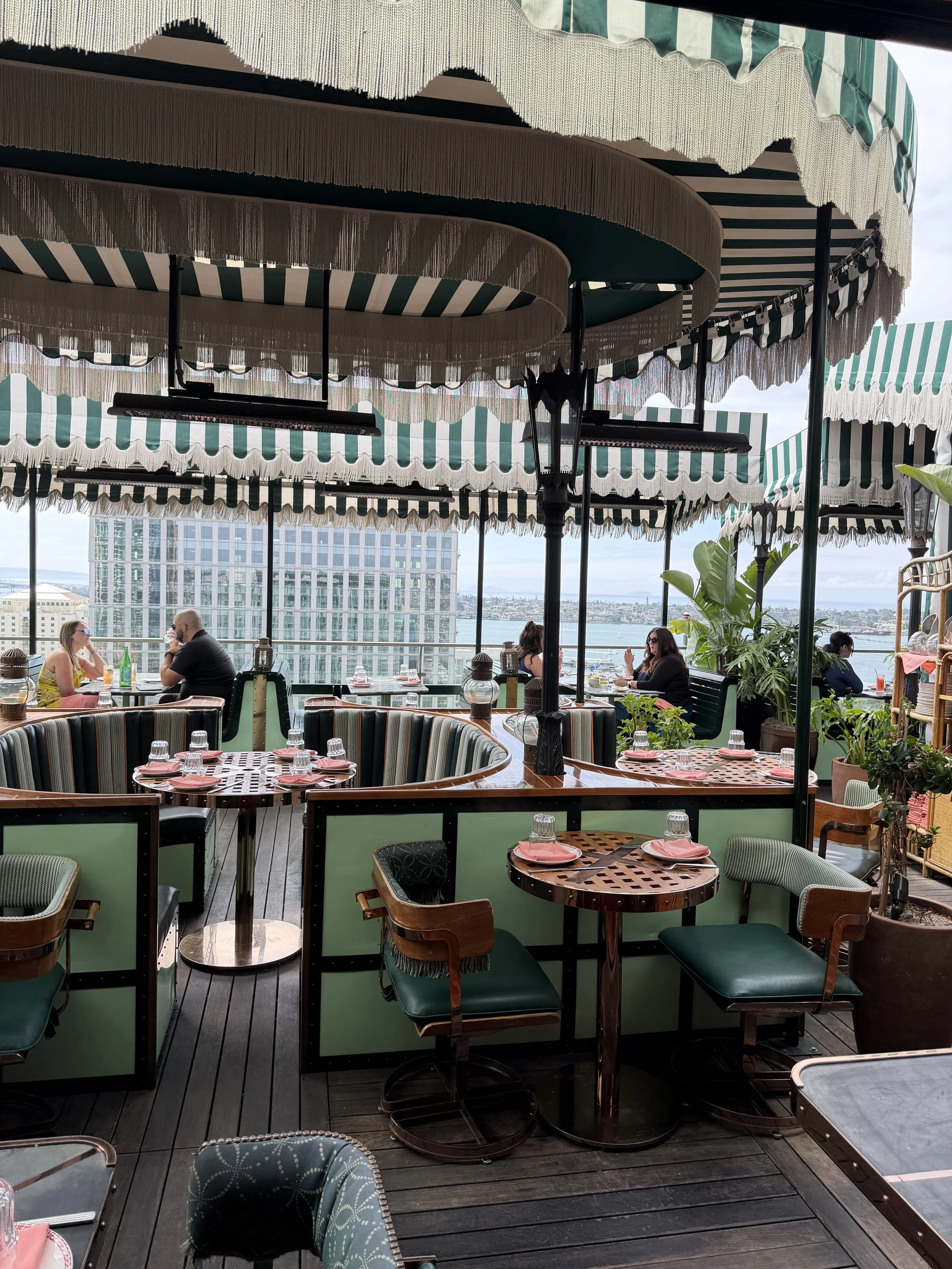 Rooftop restaurant terrace with striped canopy awnings and city views, a Supper Atlas curated dining destination