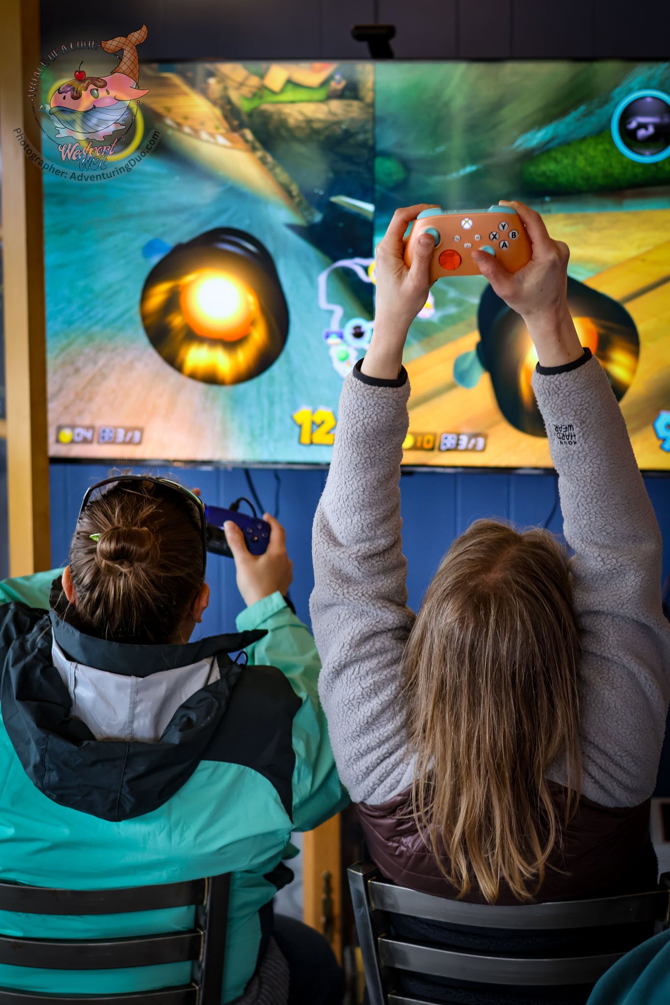 People playing a video game on a large screen using gaming controllers.