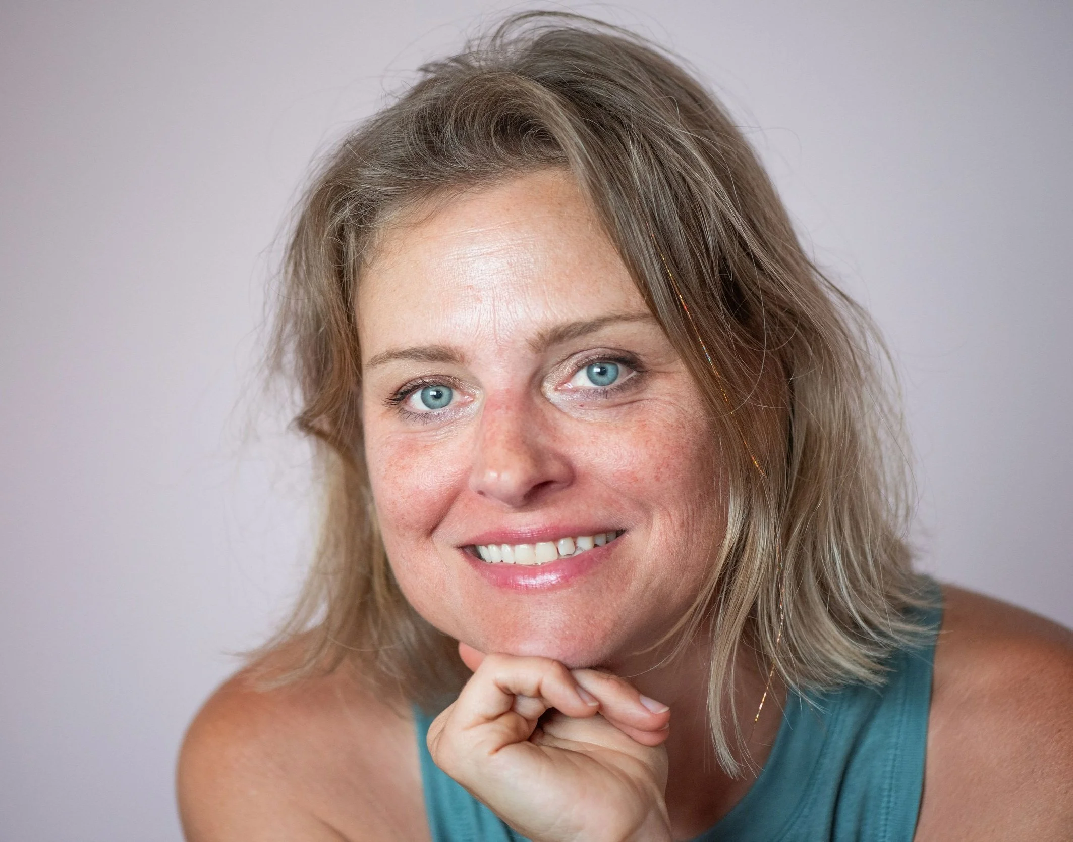 Victoria Steward smiling warmly, wearing a teal tank top, in a relaxed and natural setting.