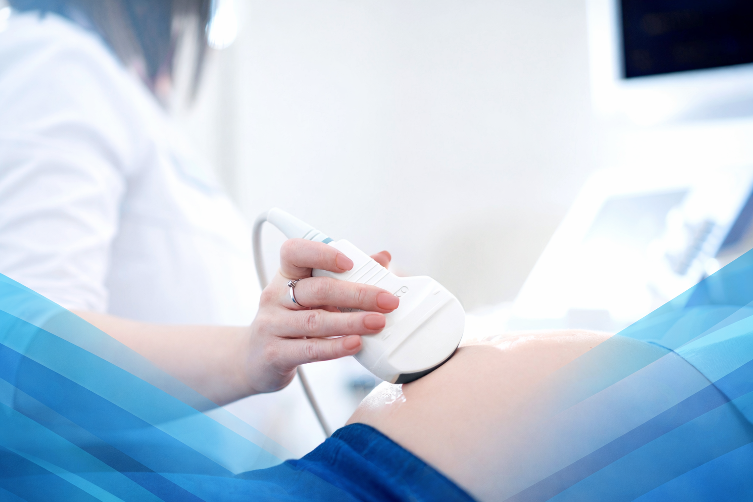 A healthcare professional using an ultrasound device on a patient's abdomen in a medical setting.