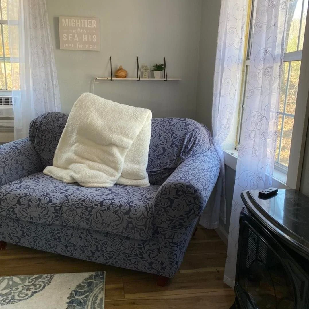 Inside the House of Prayer, with large cozy chair, blanket, and natural light.