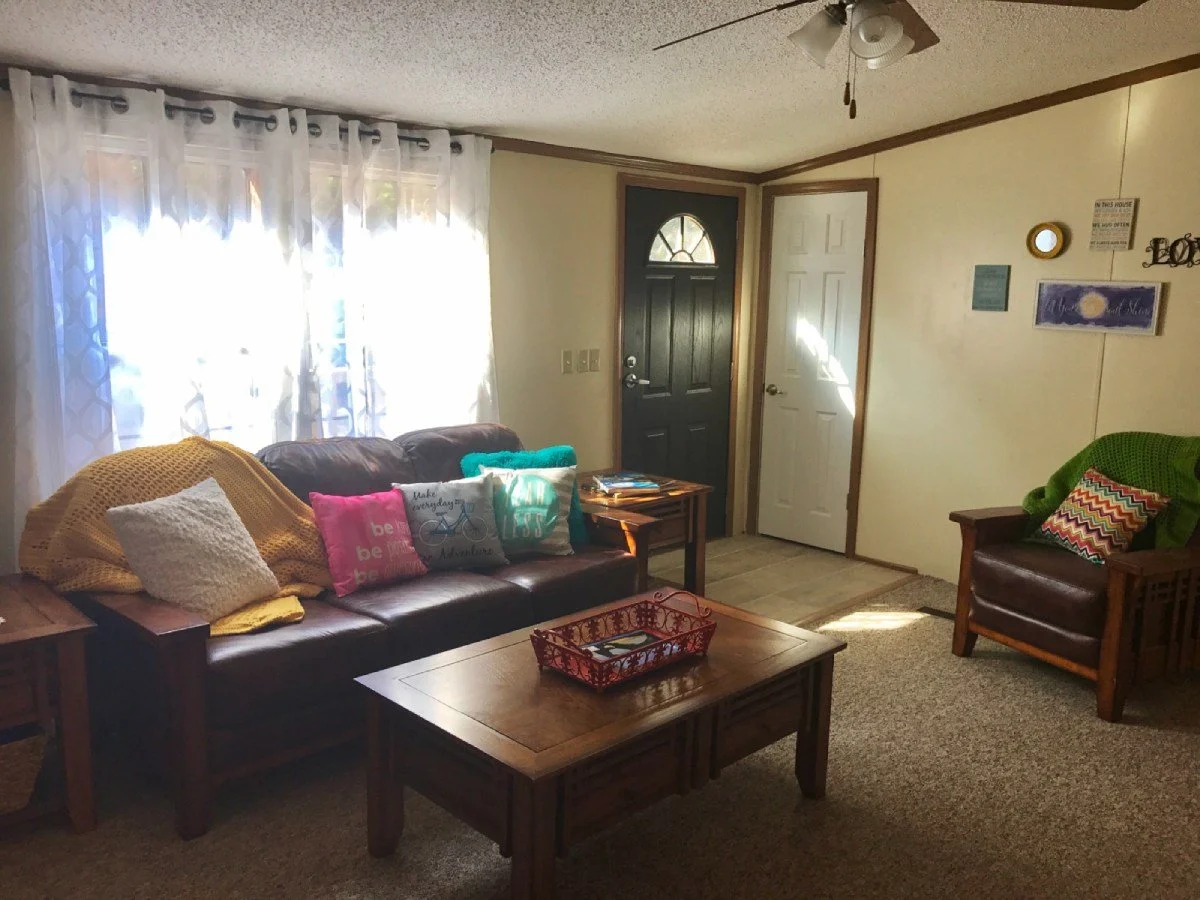 Cozy living room with coffee table, furniture, and pillows.