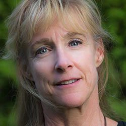 Portrait of a woman with blonde hair and a green background.