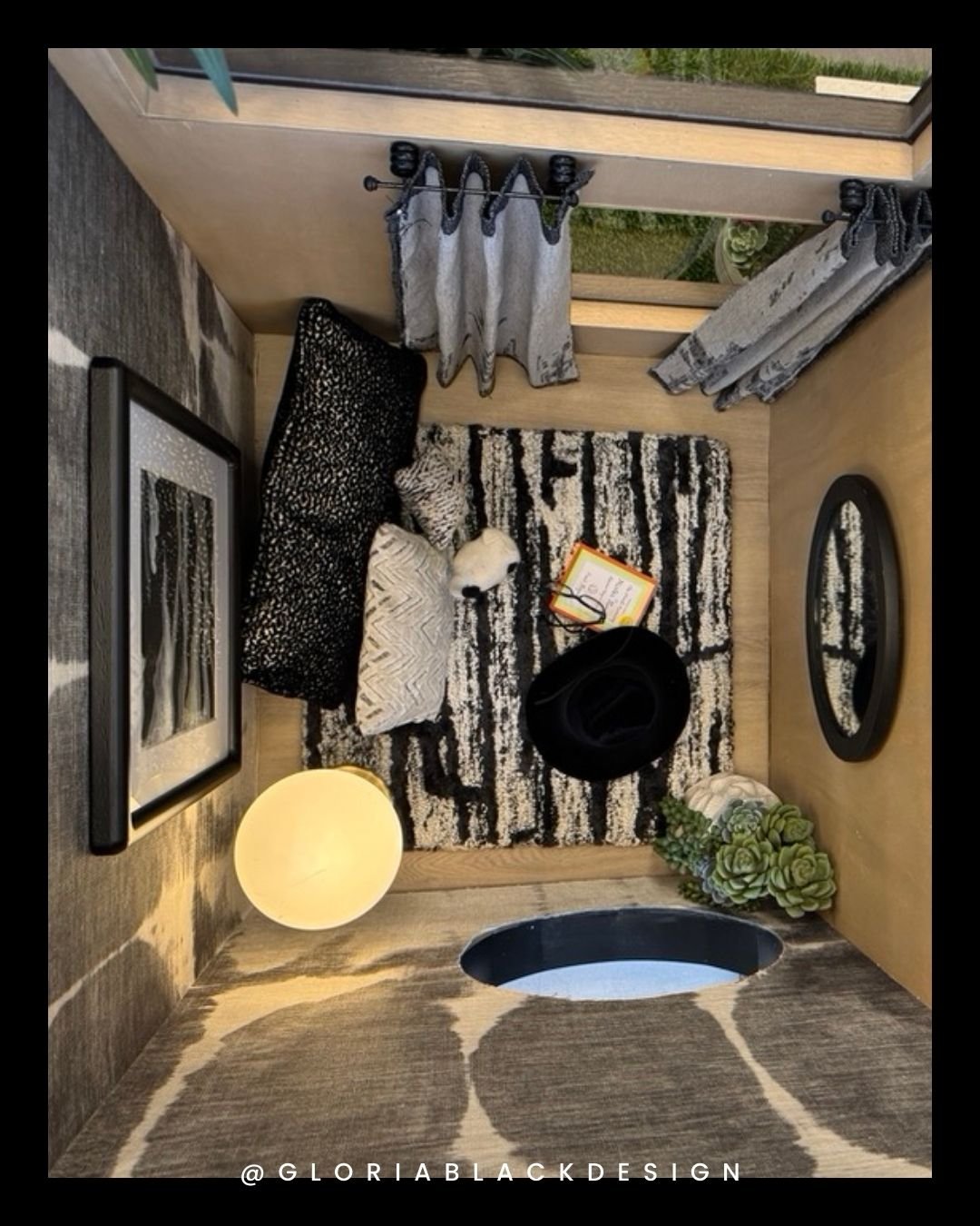 Cozy small room design with stylish decor including black and white cushions, an abstract rug, a round mirror, a small lamp, and a decorative plant. The room provides a comfortable, elegant seating area. GLORIA BLACK DESIGN Great WOOF Lodge™ for SNIP