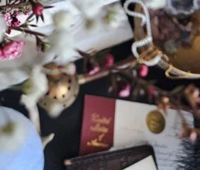 A decorative arrangement with pink and white flowers, some greenery,There are also various cards or papers and the US Patent
