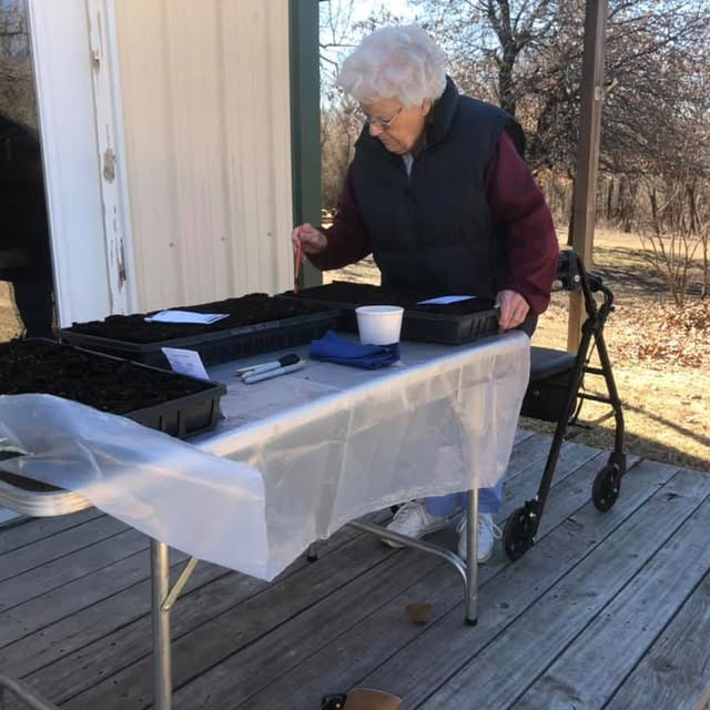 Tchinina's mother tends to an outdoor table setting.