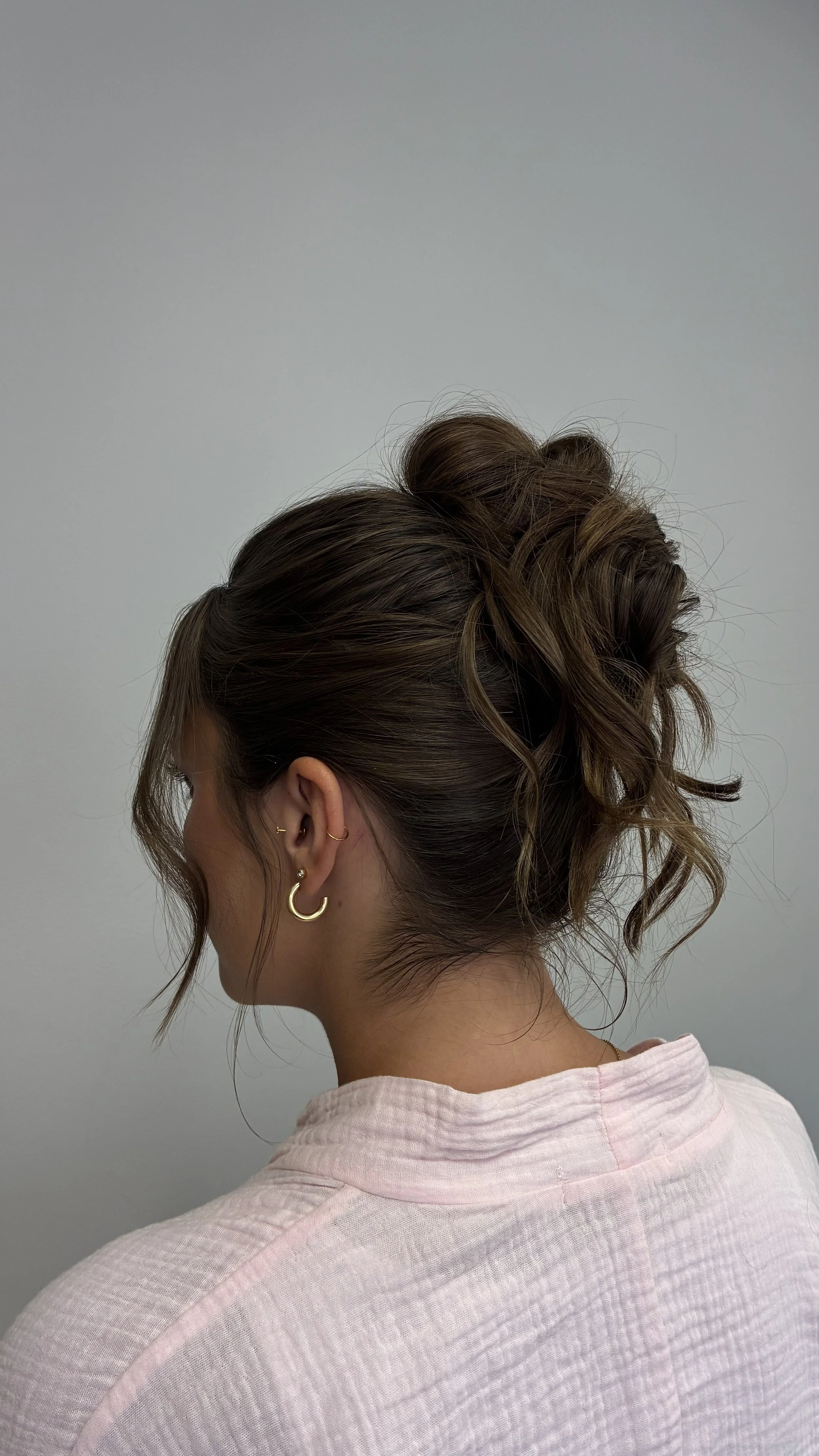 Back view of an updo on a girl with brown hair.