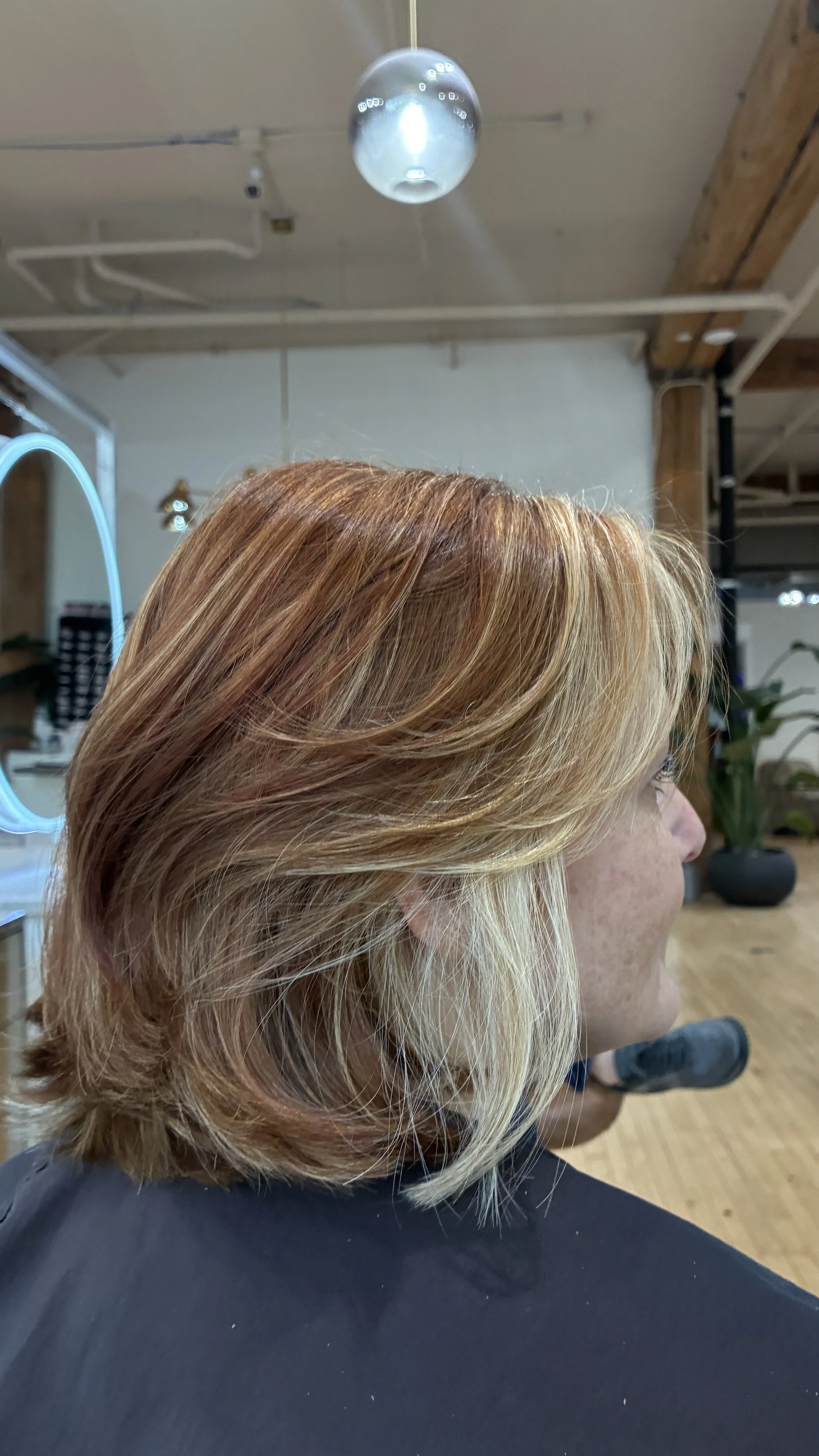 Side view of redhead with a bob and blonde money pieces.