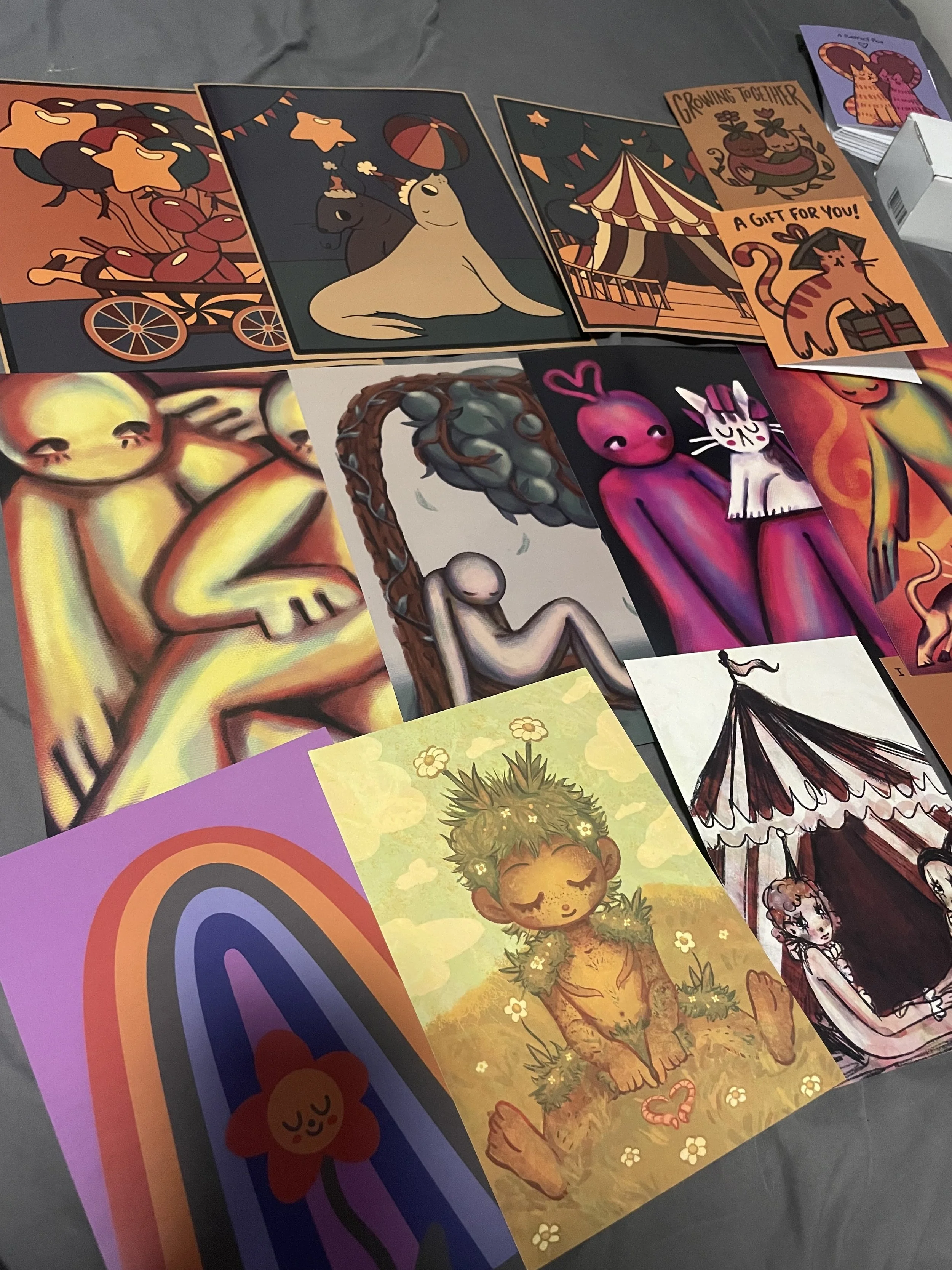 A collection of colorful illustrated cards featuring various whimsical and abstract art, including animals, humans, and fantasy scenes.