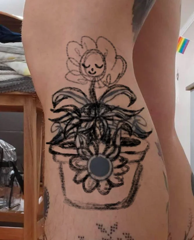 Tattoo of a smiling sunflower in a pot on a person's side