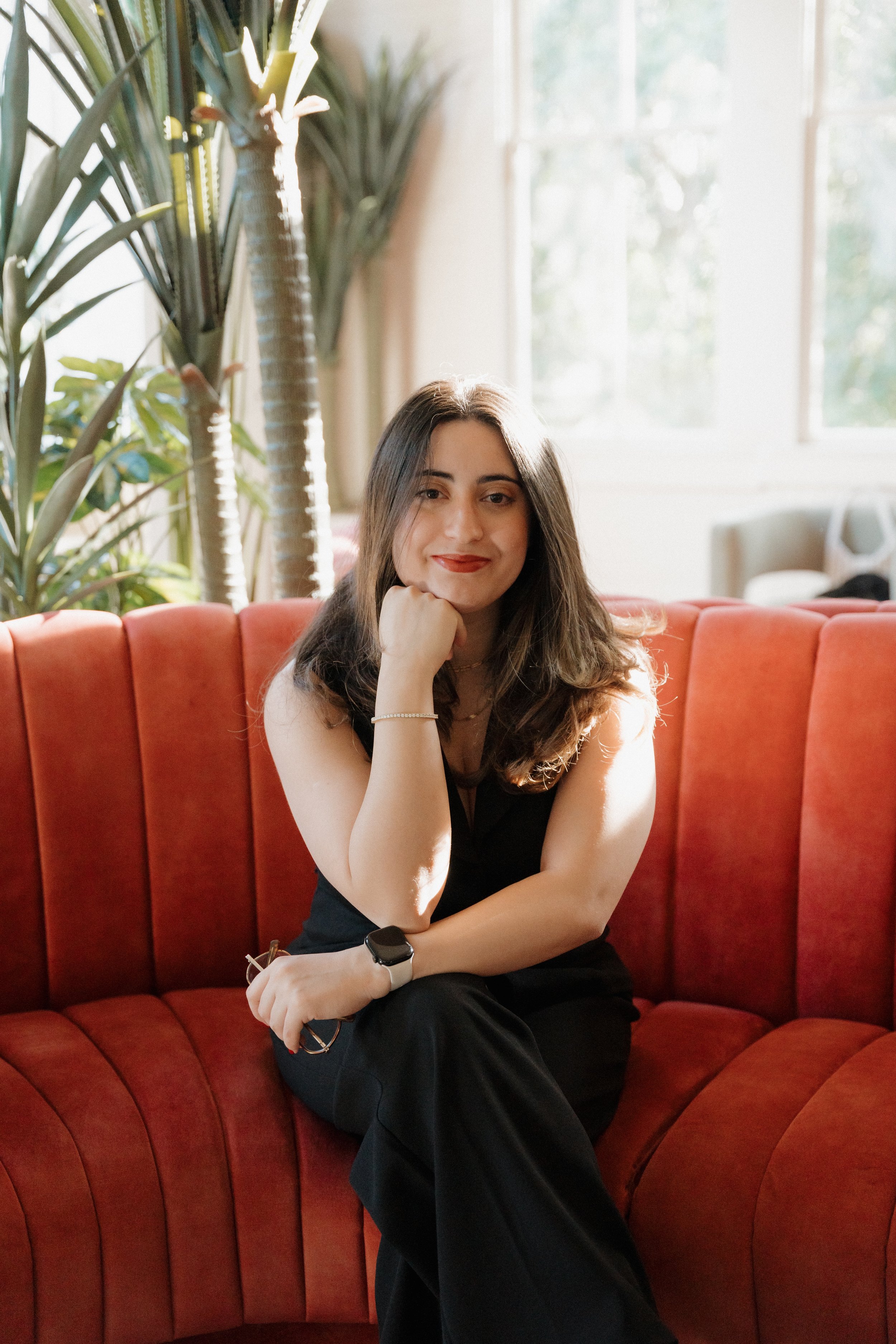 an image of Bia Braga smiling at the camera while sitting on a couch
