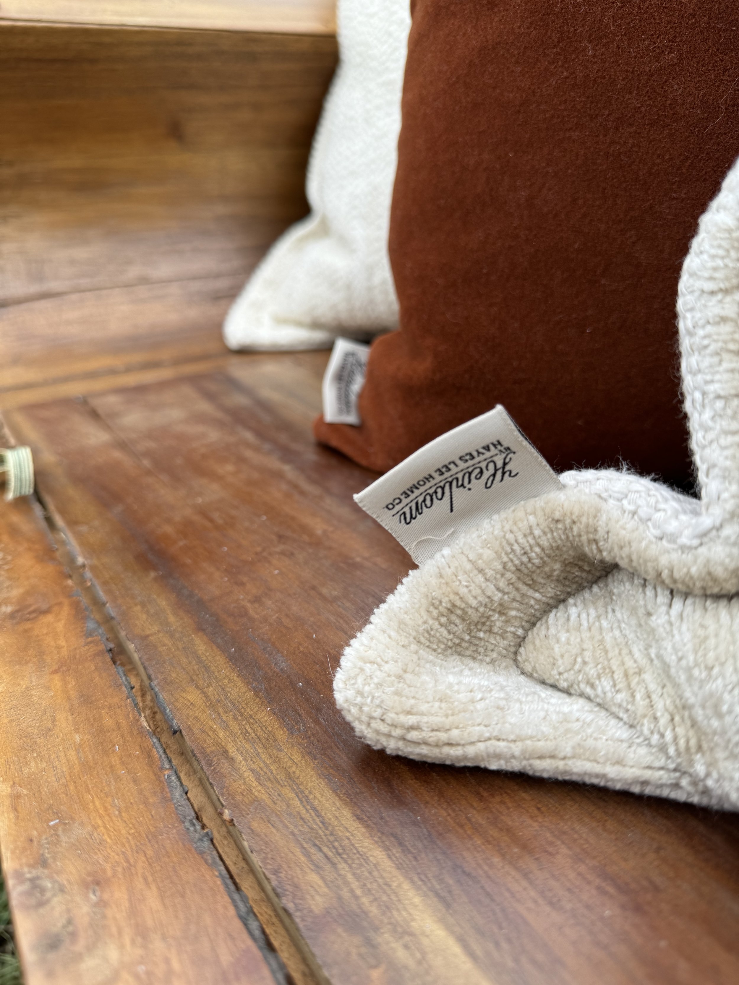 Cozy seating area with brown and cream pillows on a wooden bench