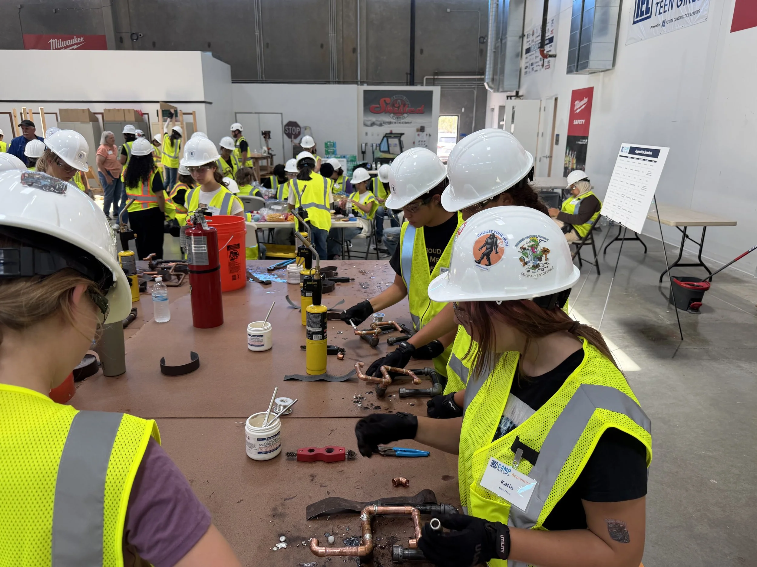 Teen girls in PPE learning to solder