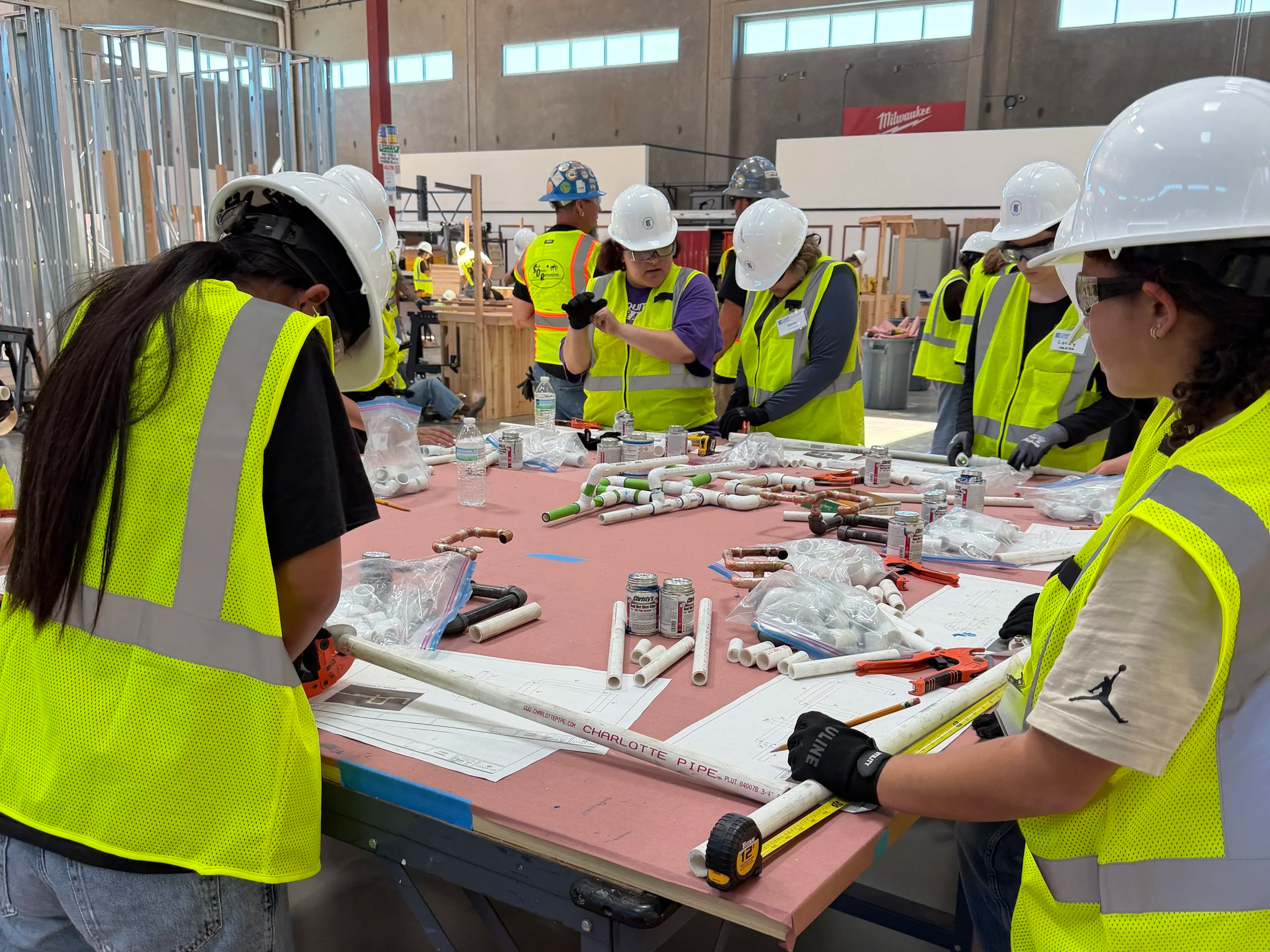 Teen girls in PPE learning assembling p-traps