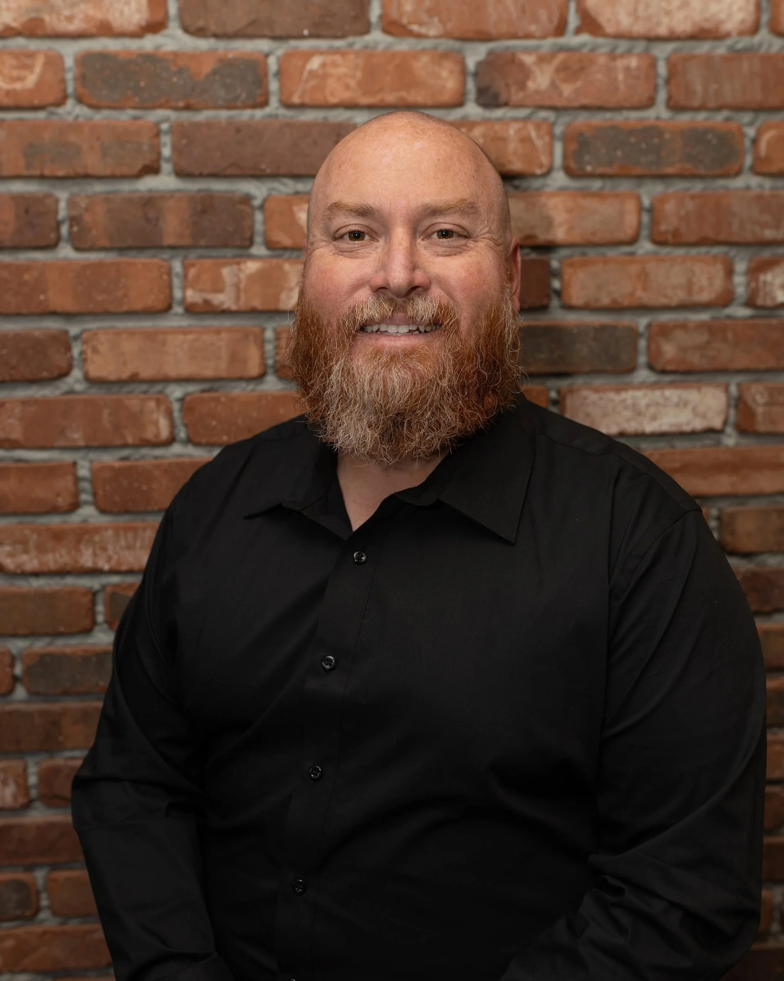 Ian Irving in front of a brick wall