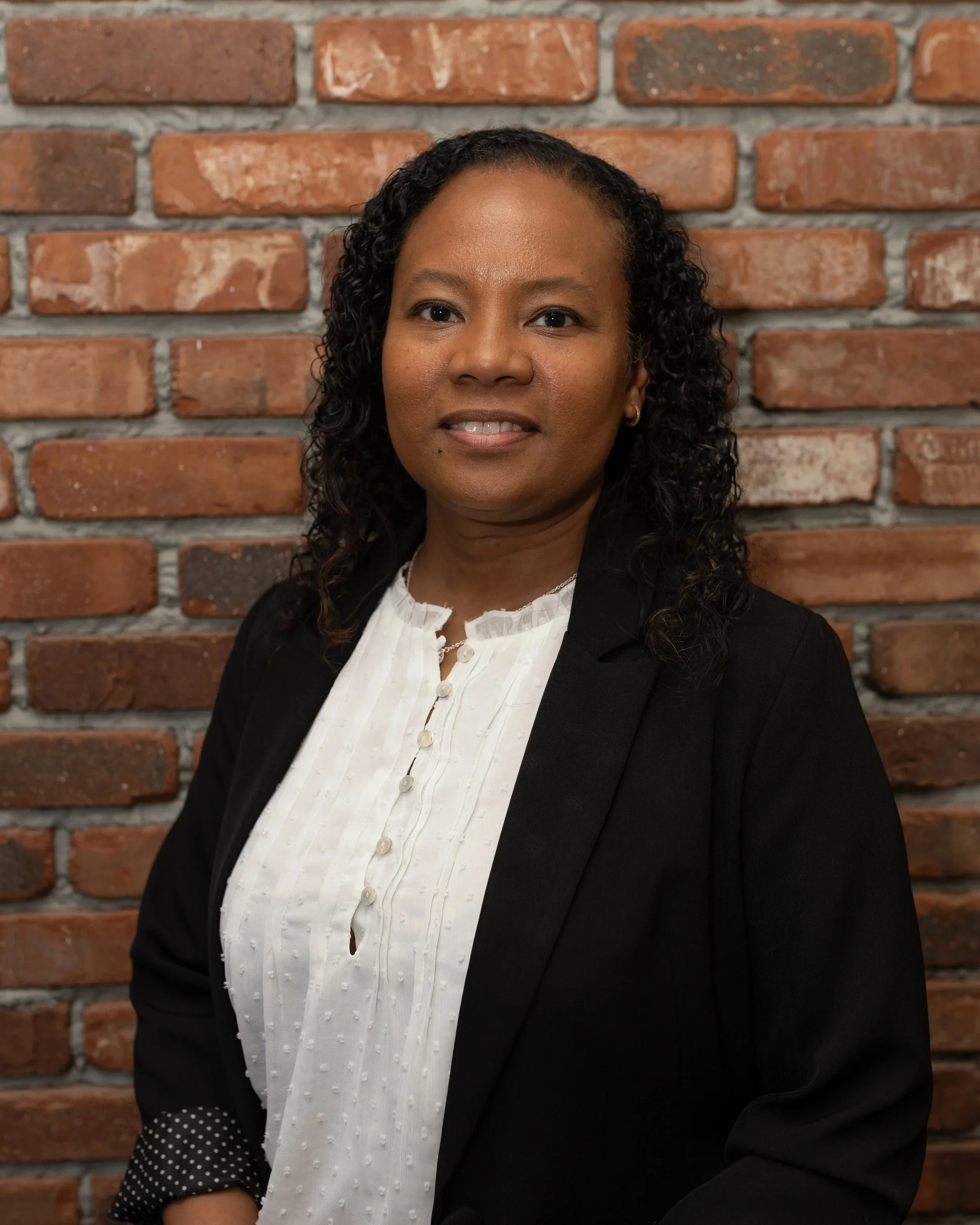 Barbara Thompson standing in front of a brick wall