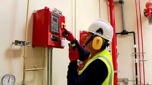 Técnico de mantenimiento revisando un cuadro eléctrico con herramientas en un entorno industrial.