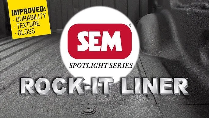 Close-up of car floor mat with SEM Spotlight Series Rock-It Liner logo and a yellow sticker highlighting improvements in durability, texture, and gloss.