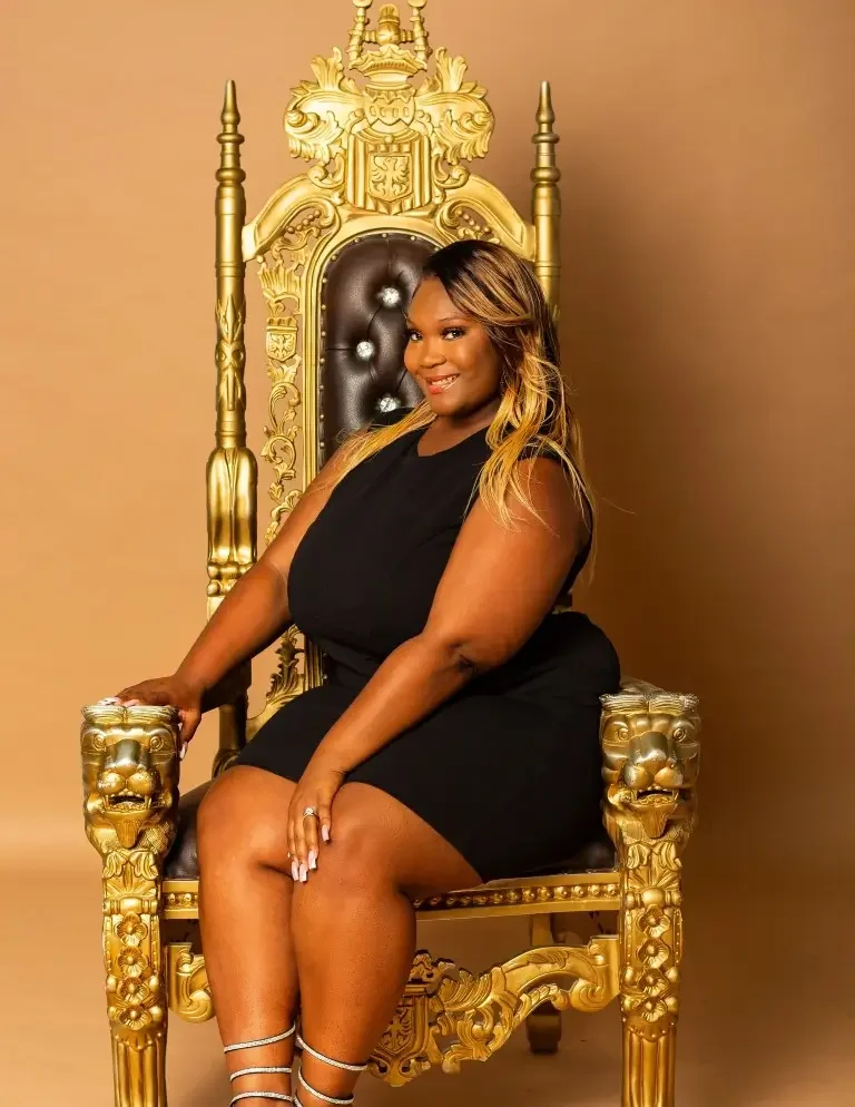 Beautiful young black woman with blonde hair sitting on a golden throne.