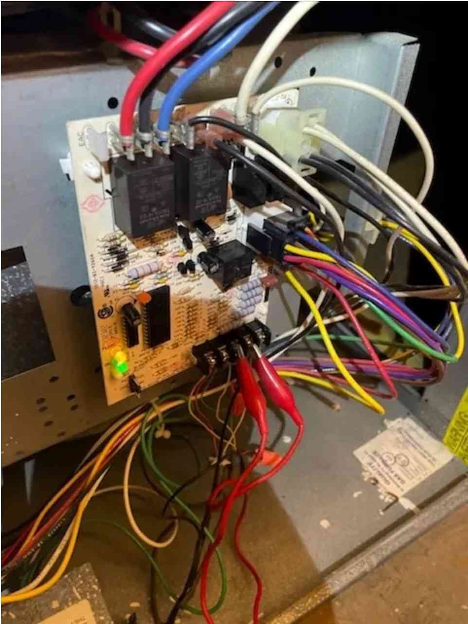 Close-up of HVAC control board with multicolored wires and active LED indicators..jpg