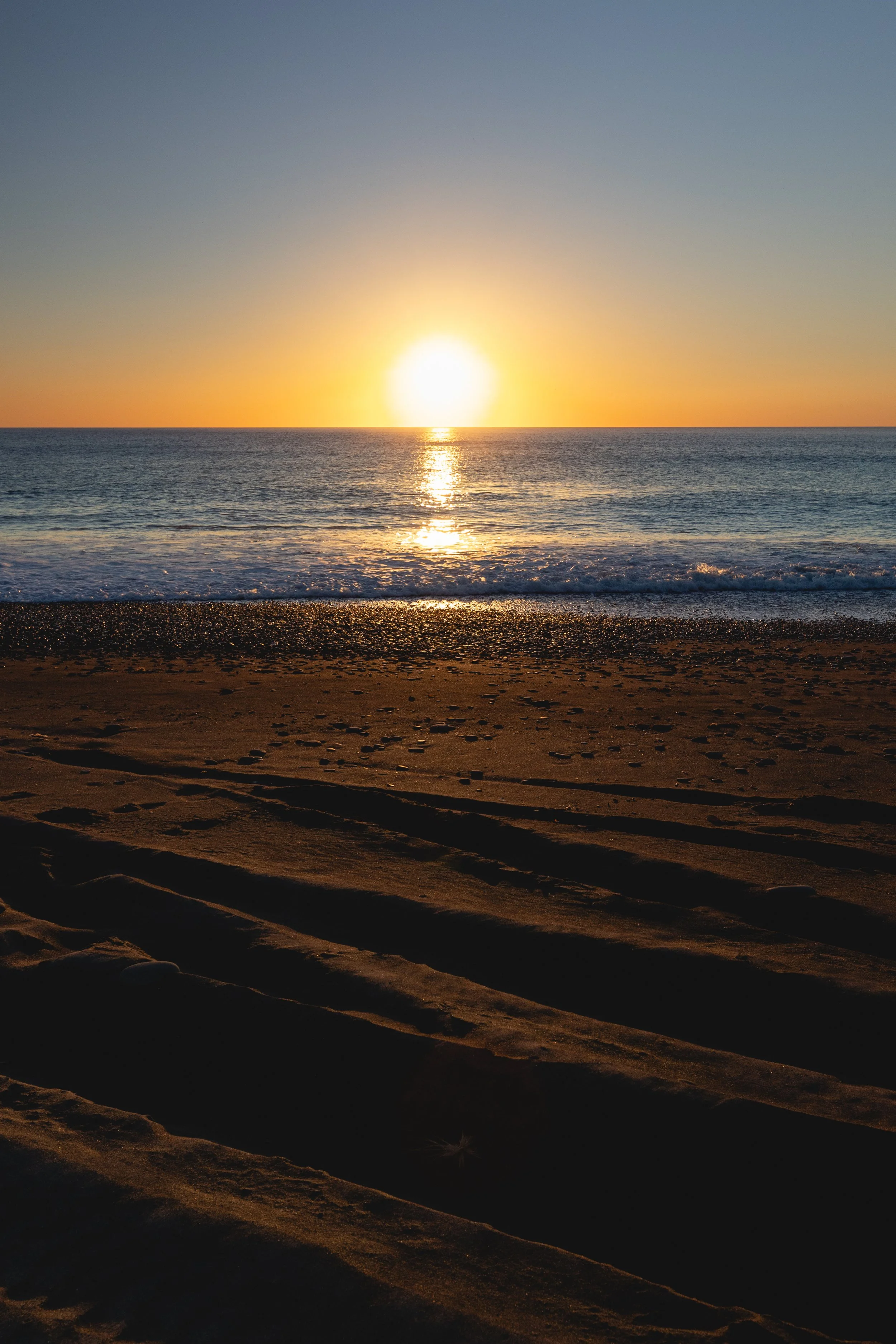 Sunrise over Rangitukia beach casting long shadows on the sand – symbolising new beginnings, cultural grounding, and the horizon of opportunity for Tairanui Administration.