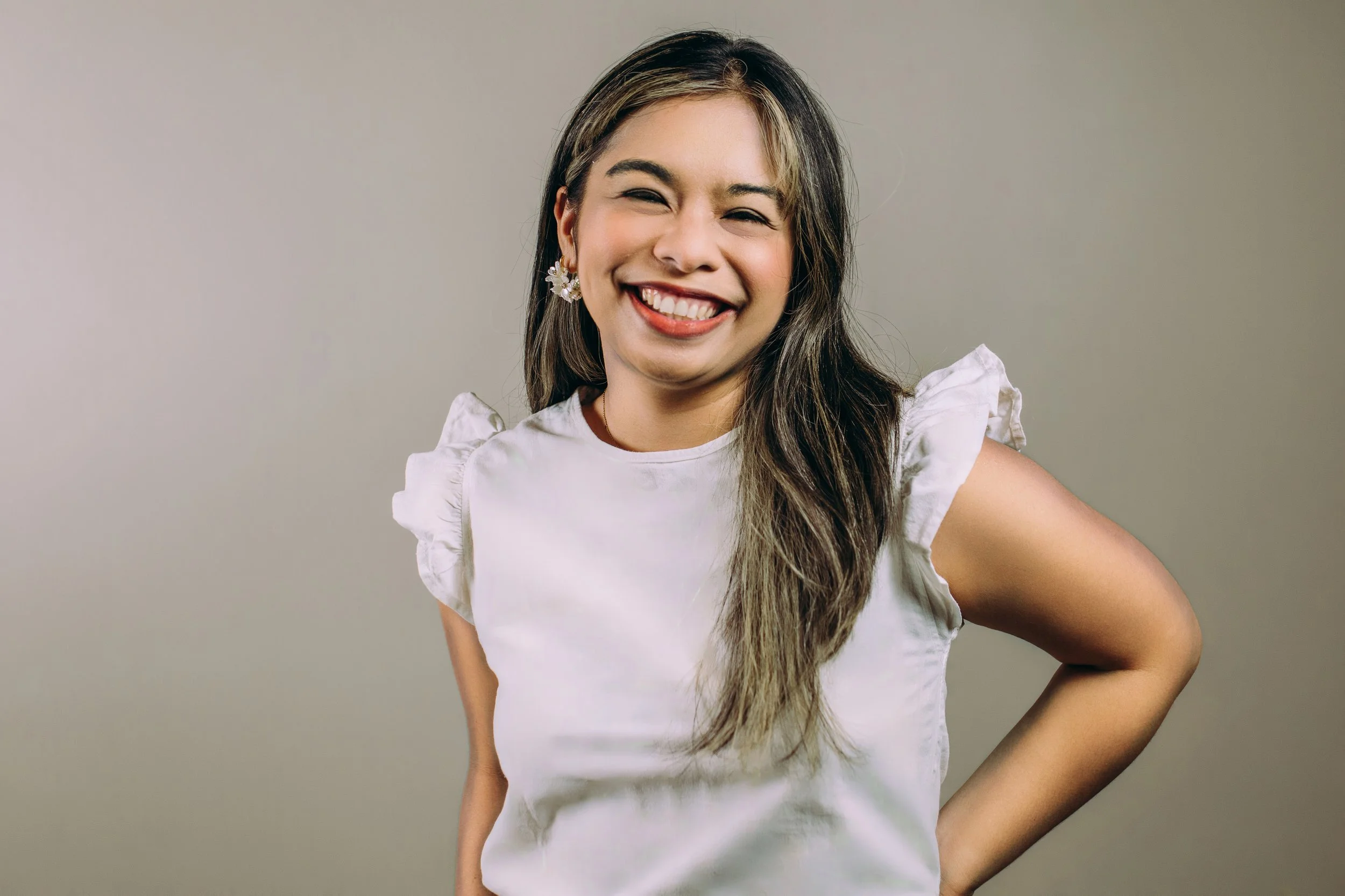 Person smiling, wearing a blue striped shirt and jeans.
