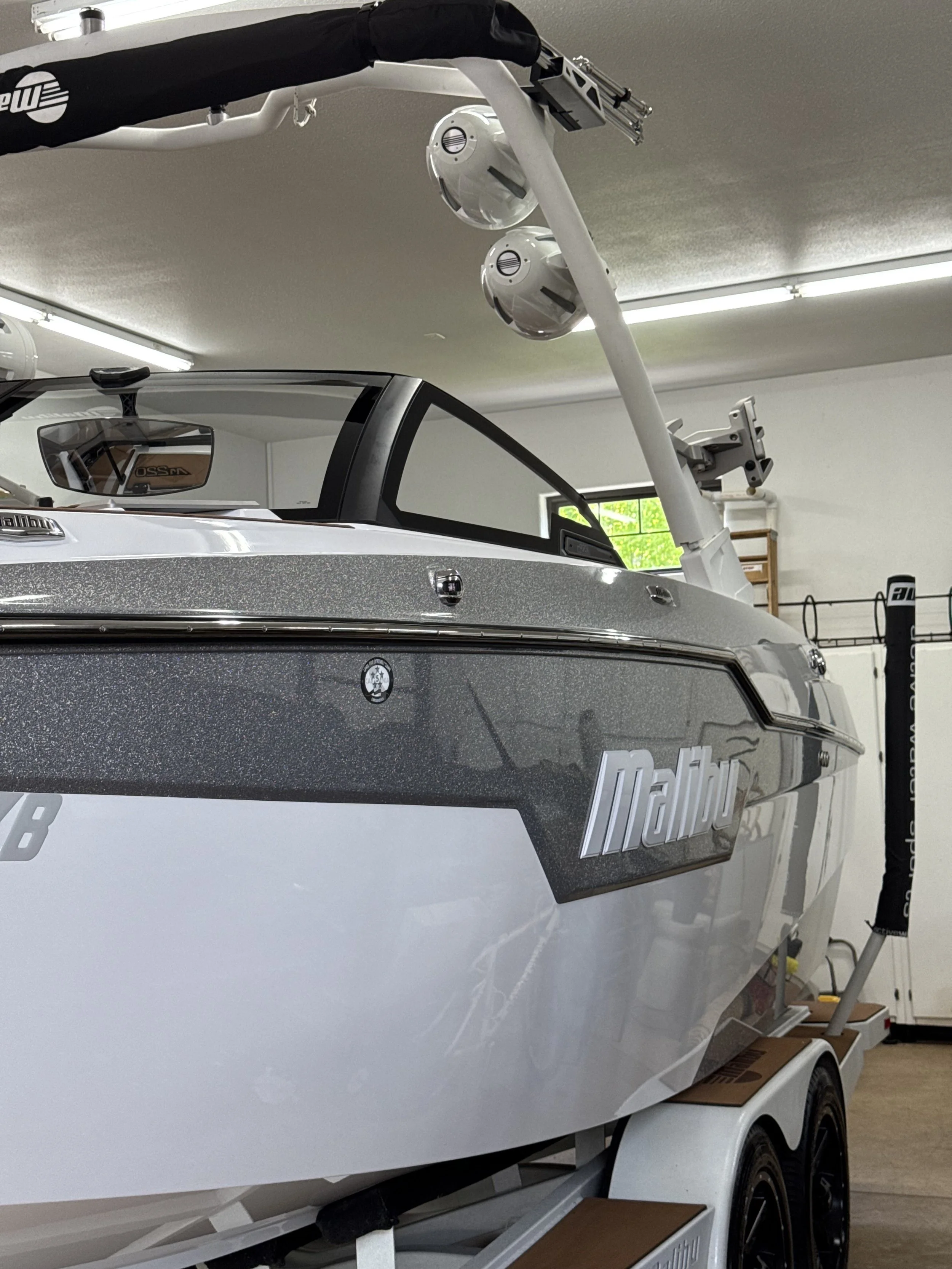 A Malibu speedboat on a trailer inside a garage.