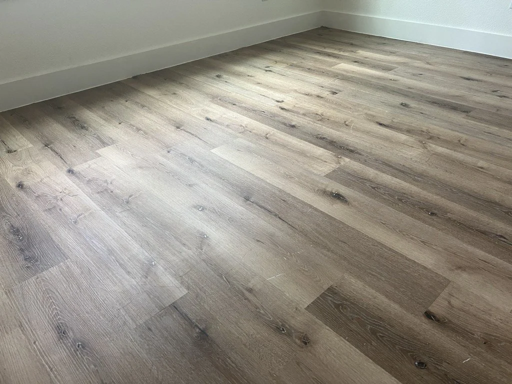 Gray luxury vinyl plank flooring in a bedroom