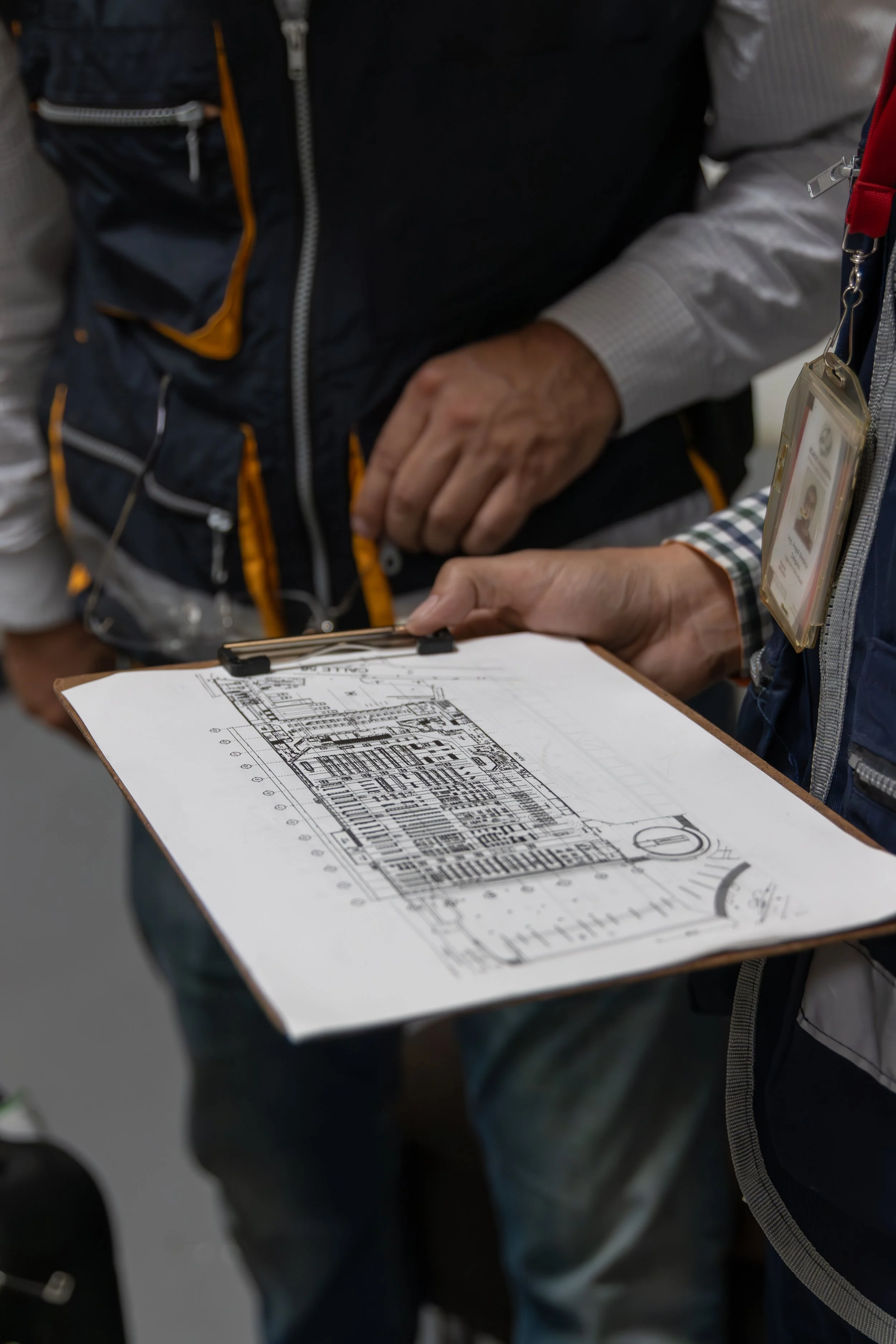 Personas revisando un plano o plano arquitectónico en una mesa.