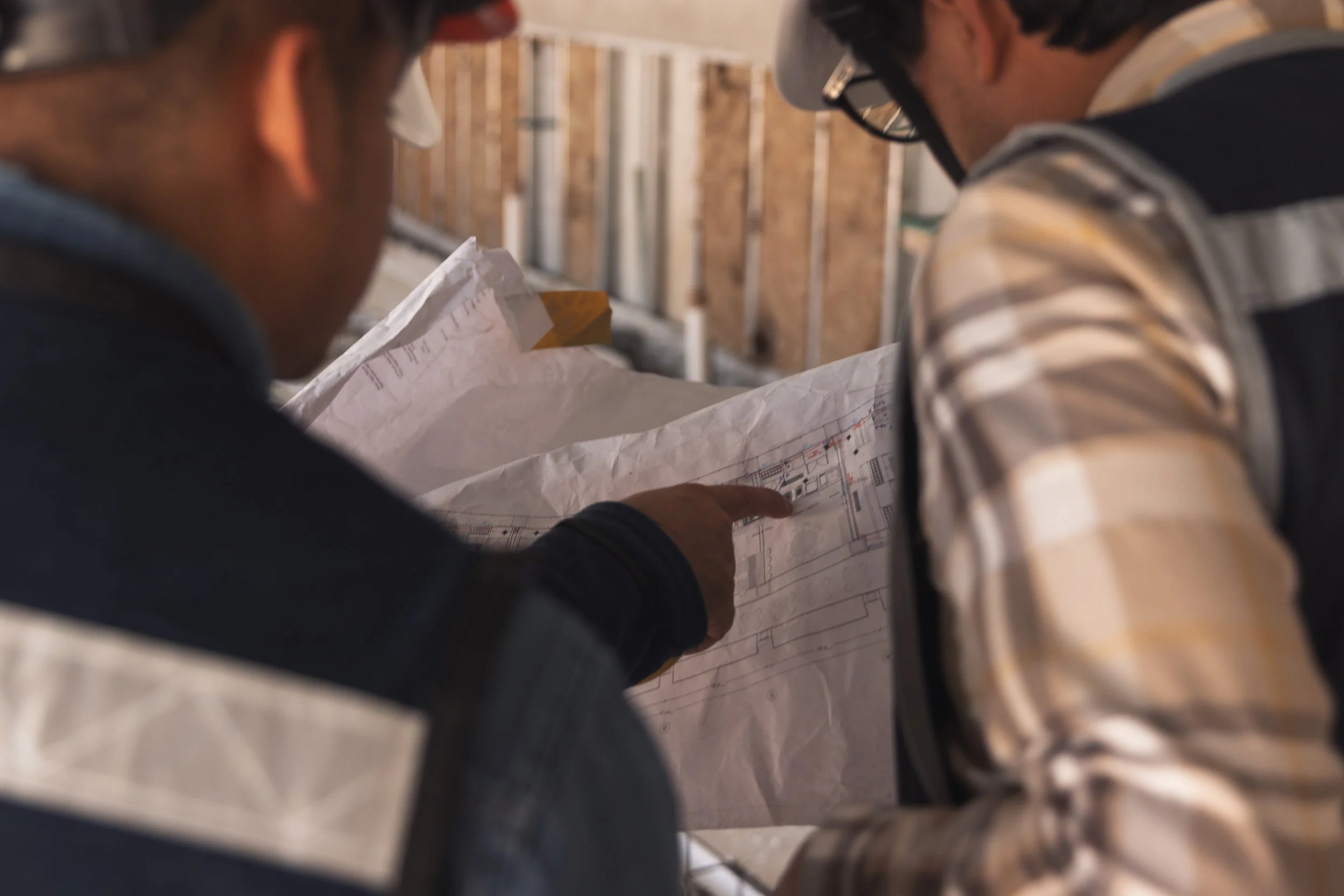 Ingenieros revisando planos en obra, representando la experiencia técnica de Grupo Empresarial ProEnvironment en proyectos estructurales sustentables.