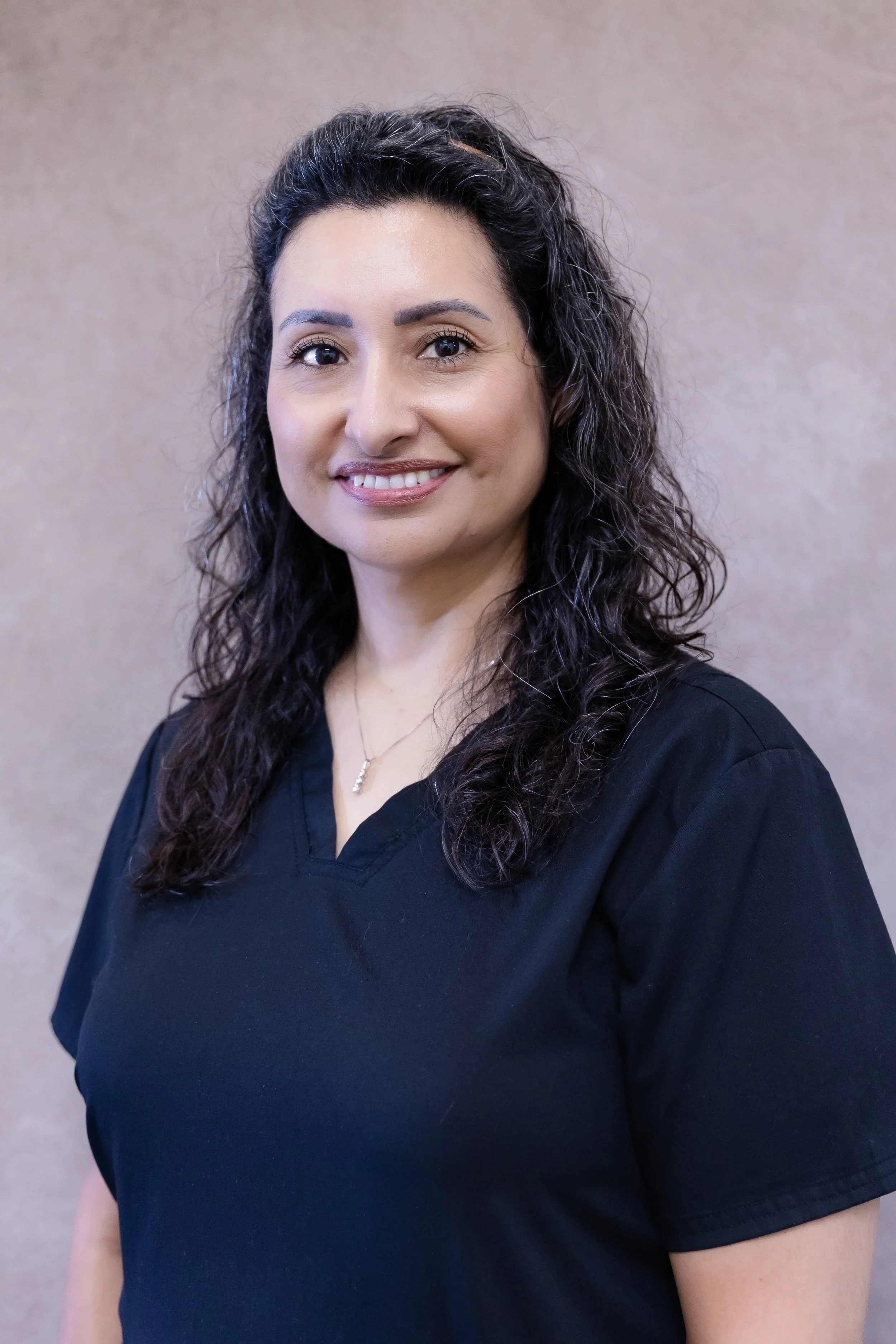 Woman sitting in a cozy room with wood-paneled walls and warm lighting