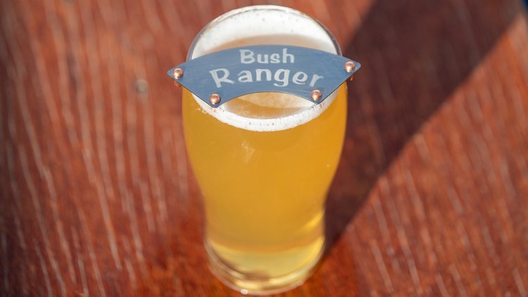 Pint glass of beer with "Bush Ranger moustache protector on top".