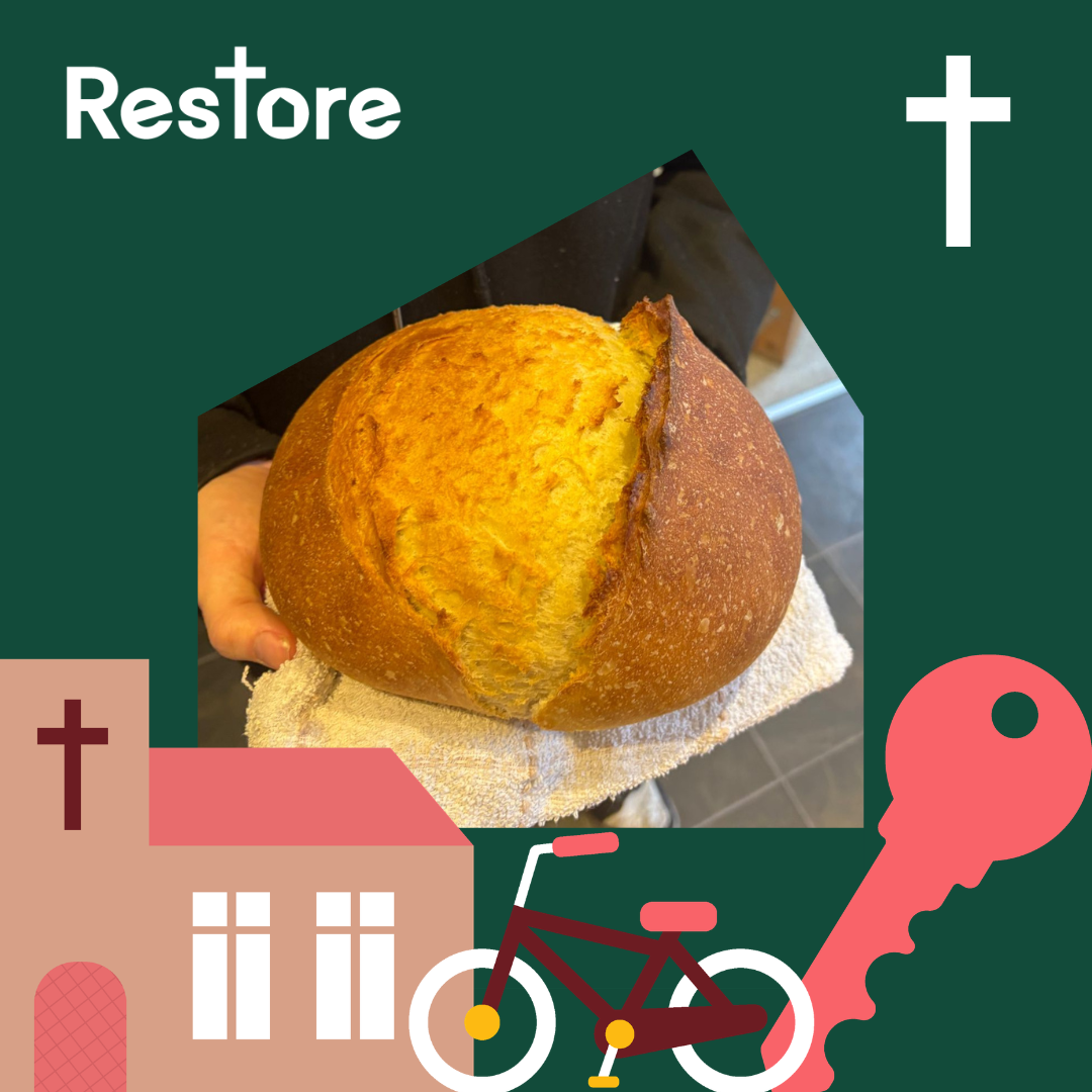 A loaf of freshly baked bread in a dark green frame with the Restore logo
