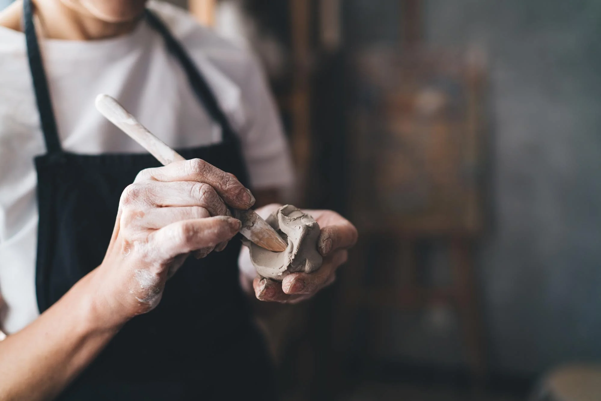 hands-shaping-clay-with-tool-in-artistic-studio.jpg